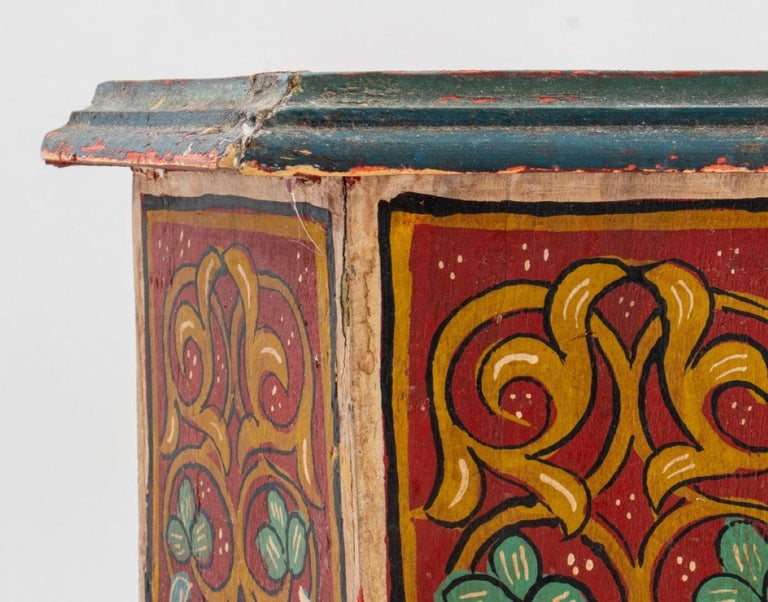 Moroccan style diminutive painted hexagonal table, the top (worn/damaged) surrounded by dark turquoise painted molding above six floral-decorated side panels. Measures: 14
