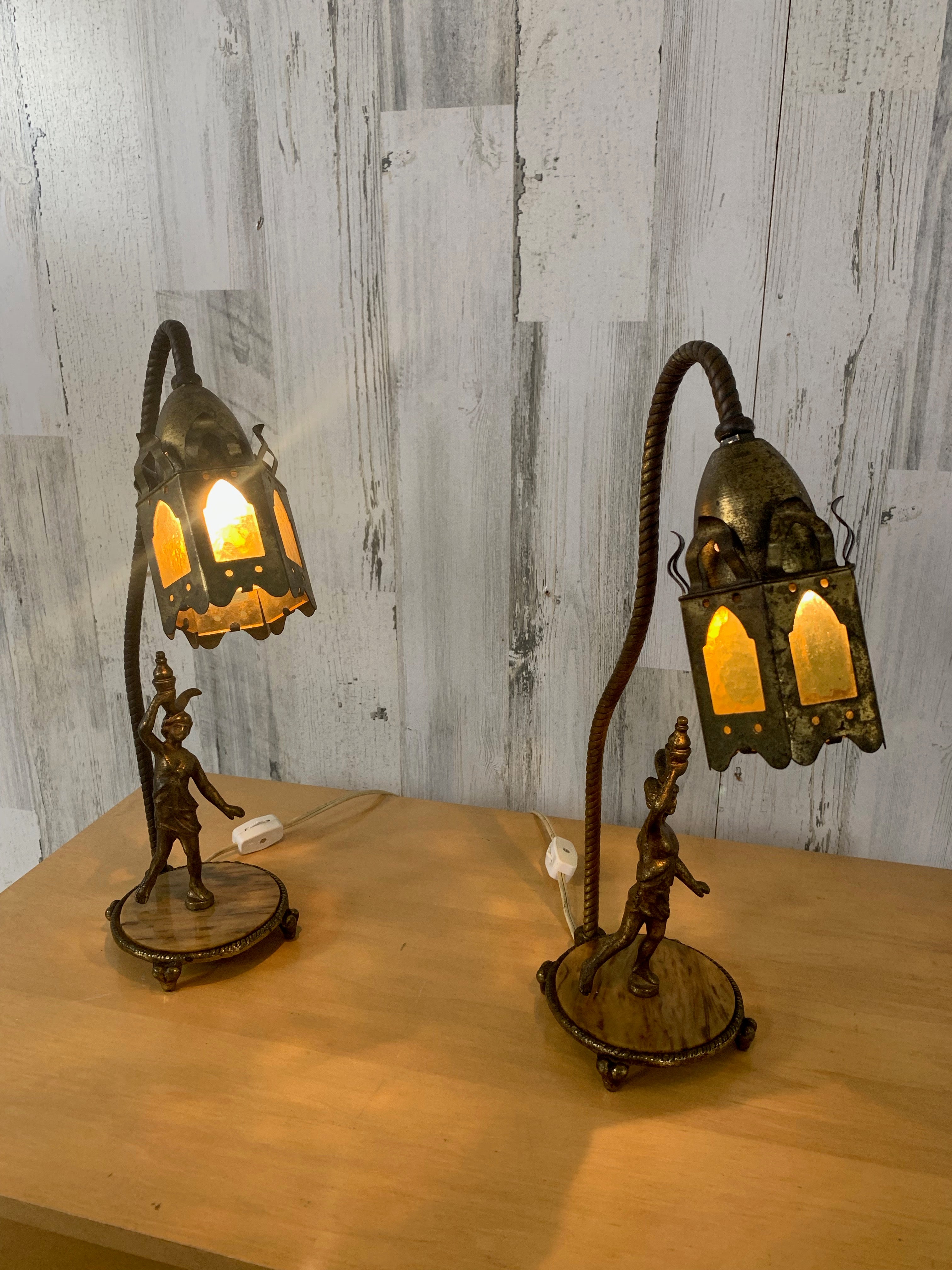 Moroccon style Lantern mantle lamps with a woman figurine mounted on faux marble base of Bakelite. The goose neck swerves upward to the lanterns giving the appearance of swaying in the wind. 