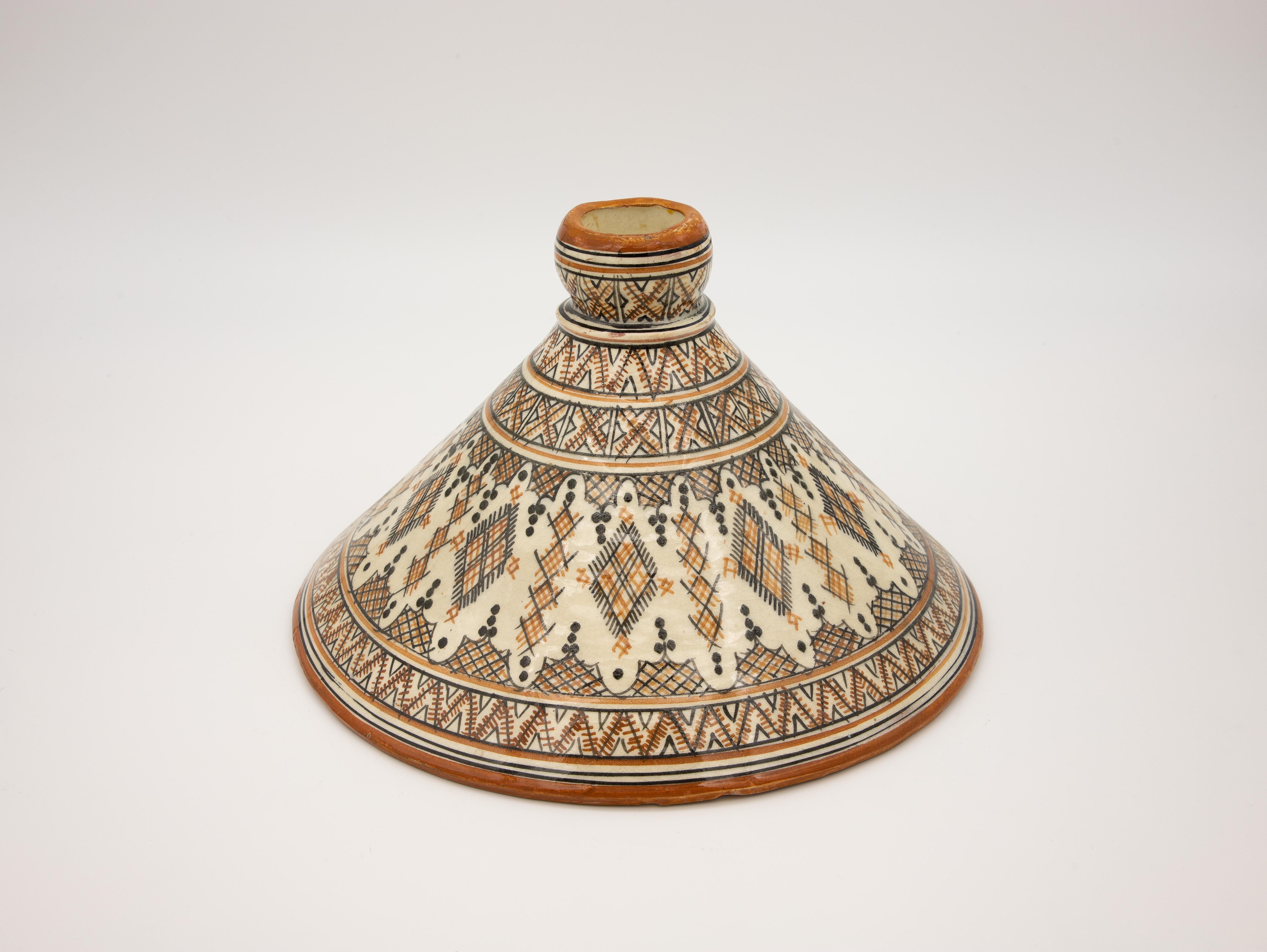 A brown, black, and honey-colored Moroccan Tajine for cooking. Made in Morocco in the 1930s.
Wear consistent with age and use.