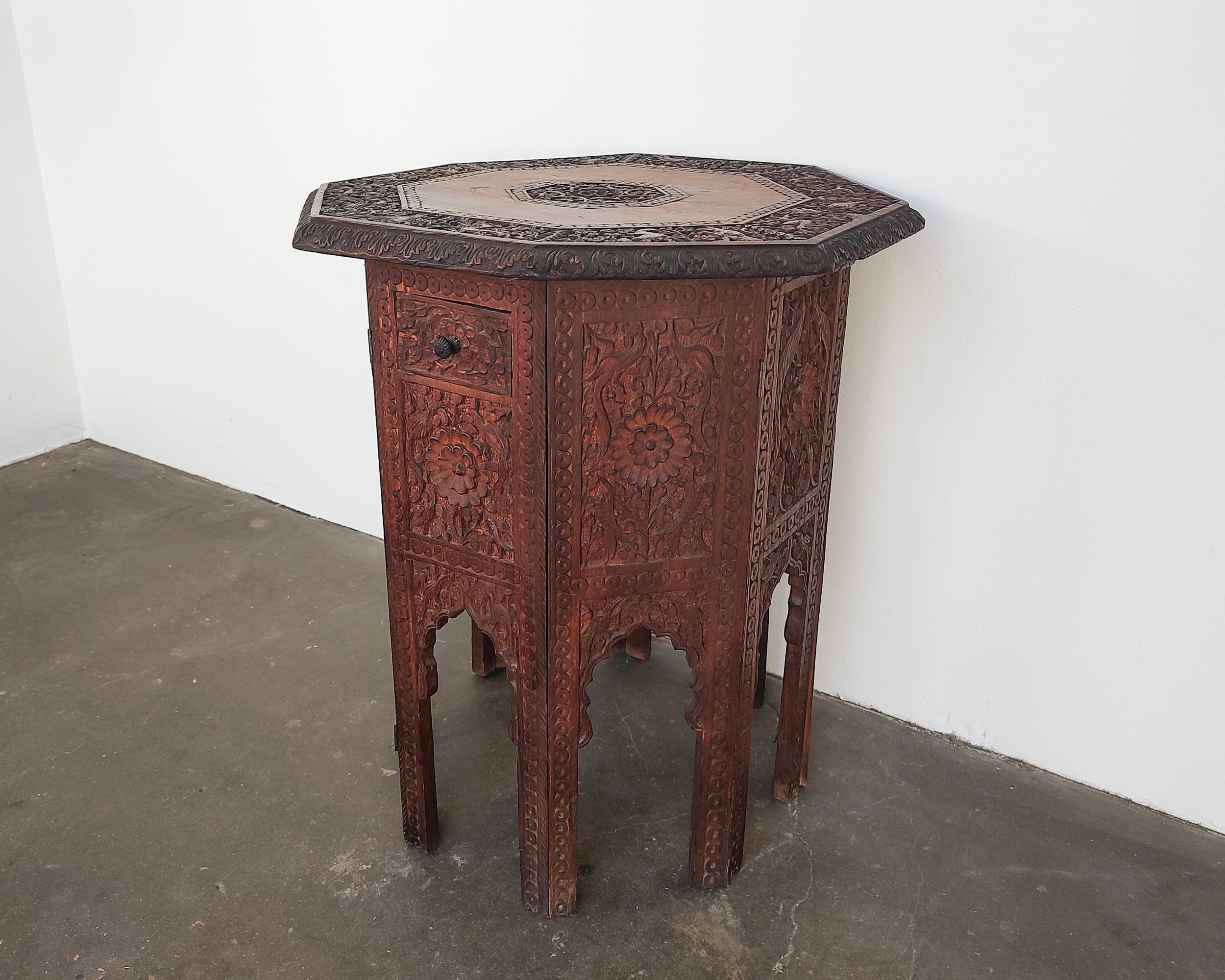 Intricate hand-carved antique teak wood Moroccan side table. Octagonal shape with beautiful cutout arched legs. Two small drawers on either side. Overall great original condition, one small chip to wood on one of the drawer pulls.

19.5