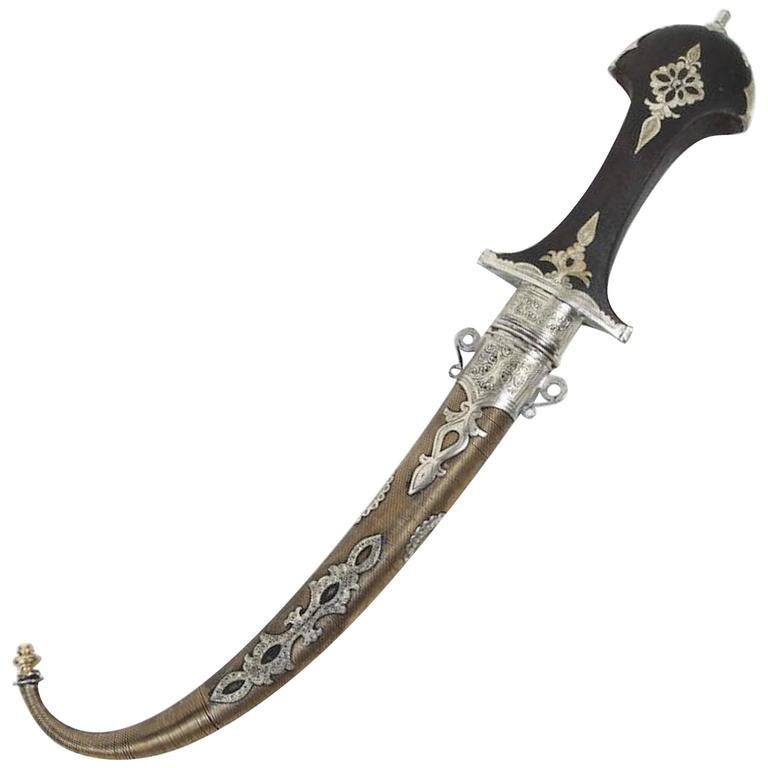 Moroccan Tribal Khoumya Daggers.
Handcrafted by Artisans in Morocco, very fine quality craftsmanship with a wooden grip engraved with Moroccan silver and chiselled in scrolling Moorish foliage.
Handcrafted Moroccan brass dagger in mixed metal,