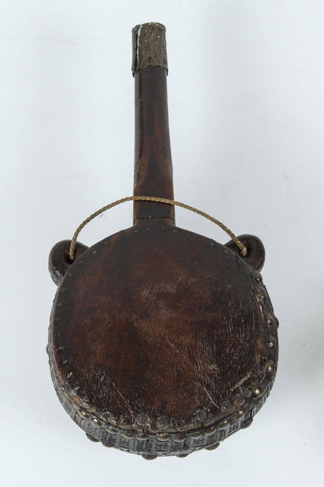 Moroccan tribal flask.
19th Century studded flasks finely engraved designs.
Collector flask in large carved wooden vessel with brass studded and leather covered.
Dimensions: 10