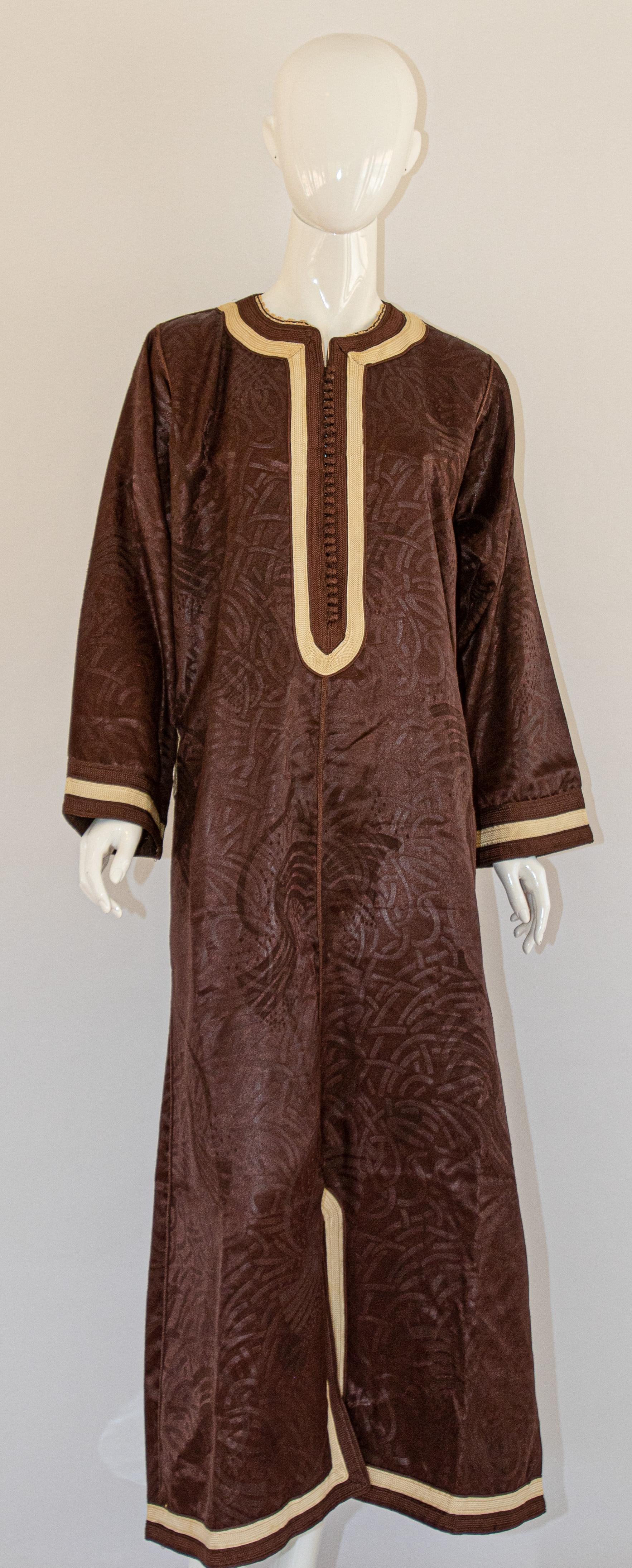 Vintage Moorish Moroccan brown caftan, circa 1970s.
Vintage Moorish Maxi Dress kaftan in brown color with gold trim embroideries.
Long sleeves, side pockets.
Size medium to large. Unisex.
Measurements: 
Bust: 44