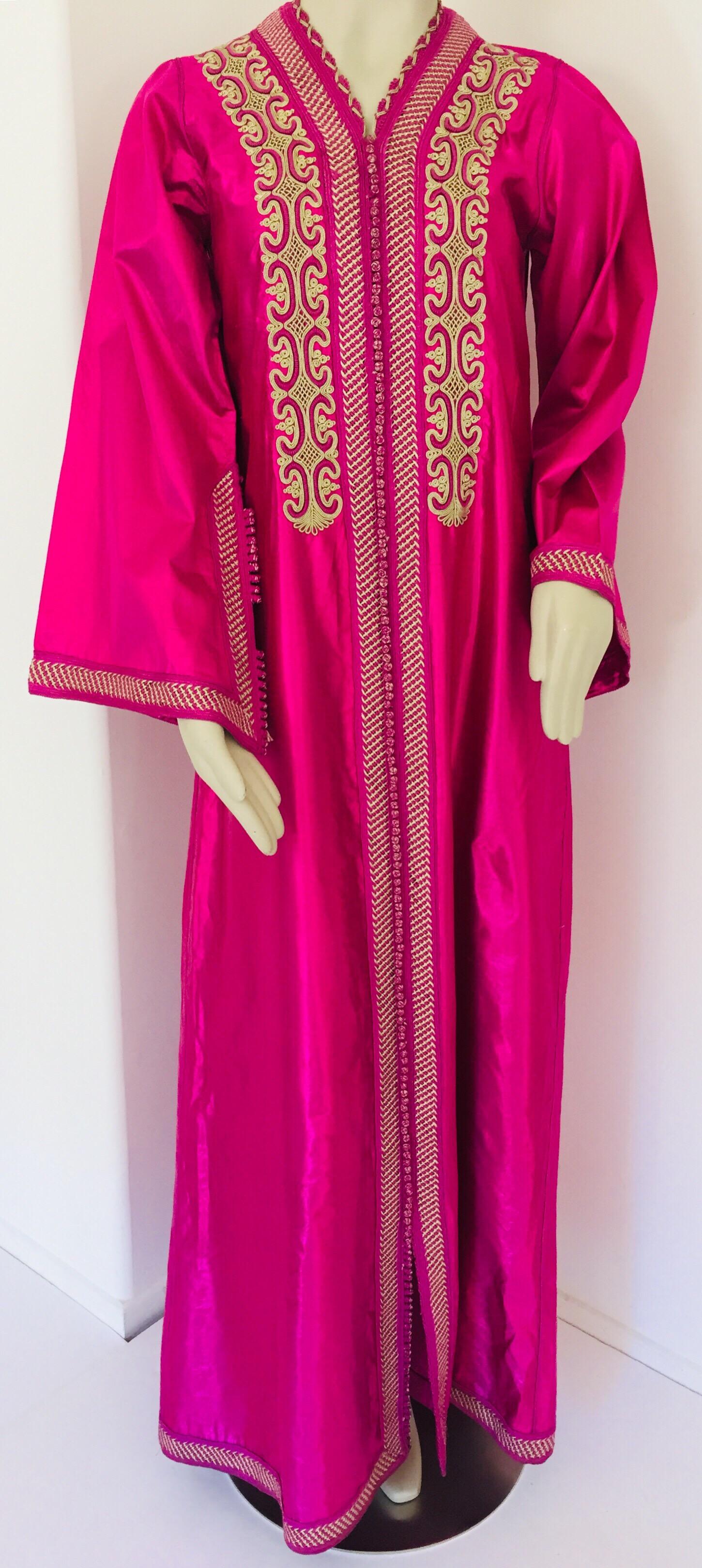 Moroccan caftan, evening or interior adorned with front embroideries.
Handcrafted vintage exotic 1970s kaftan gown.
The luminous pink metallic fabric maxi dress caftan is adorned in front with floral embroidered patterned and trim.
Great chic