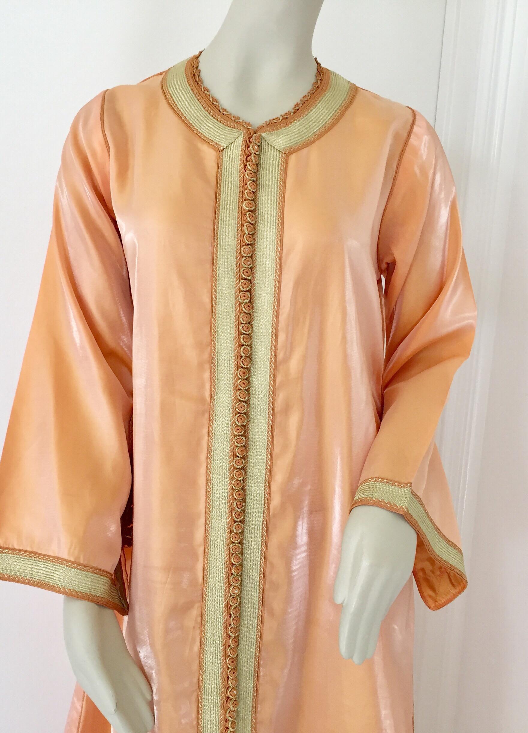 Moroccan caftan, evening or interior adorned with white pearls.
Handcrafted vintage exotic 1970s kaftan gown.
The luminous orange maxi dress caftan is adorned in front with floral embroidered patterned and gold trim.
Great chic maxi dress