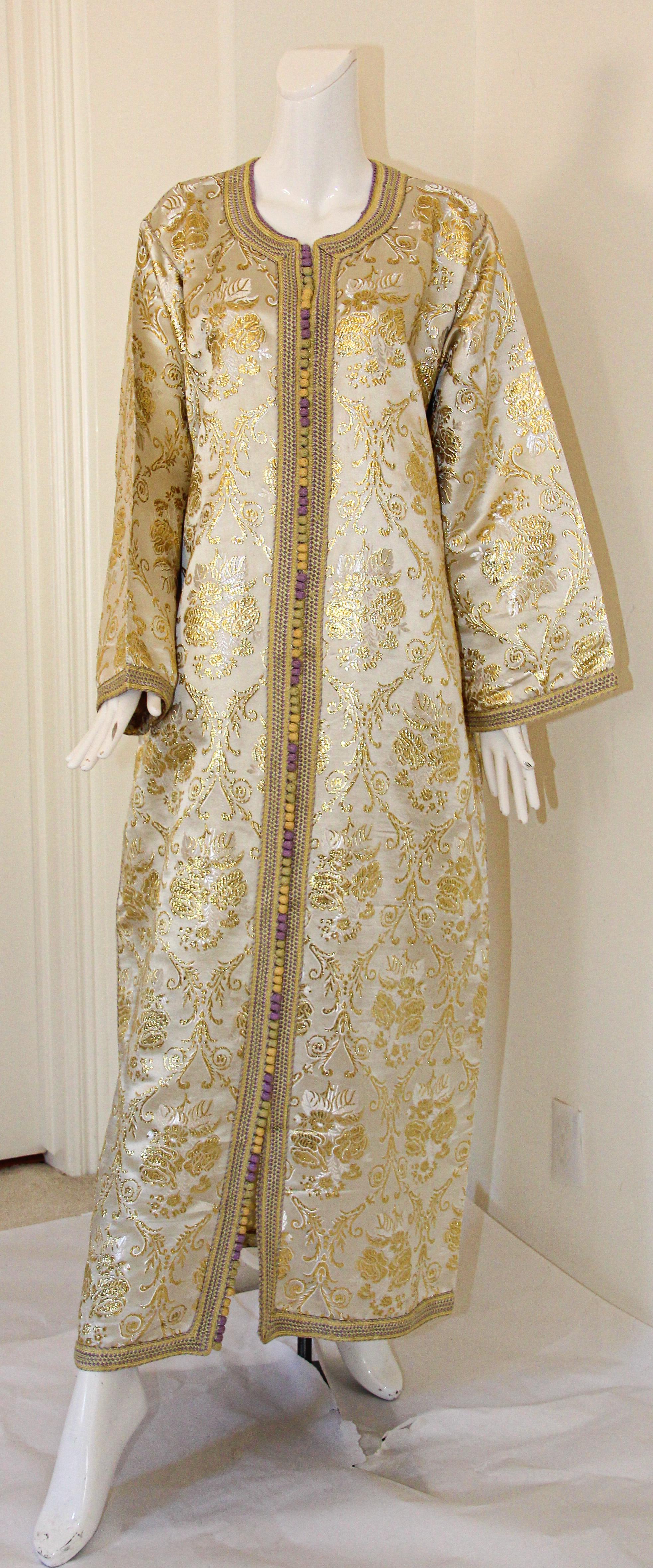 Moroccan vintage gold and silver metallic floral brocade dress kaftan with gold trim.
Handmade ceremonial caftan from North Africa, Morocco.
Vintage exotic 1970s metallic brocade caftan gown.
The luminous cream and gold metallic caftan maxi dress
