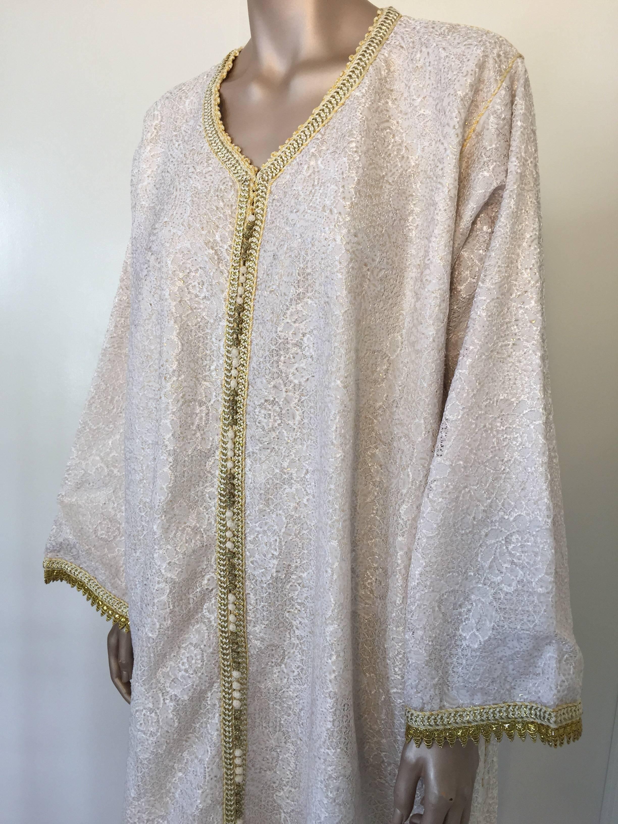 Caftan marocain, robe de soirée ou d'intérieur en dentelle blanche et dorée avec bordure dorée.
Robe caftan métallique blanche et dorée faite à la main, exotique et vintage des années 1970, caftan de cérémonie d'Afrique du Nord, Maroc.
Le caftan de