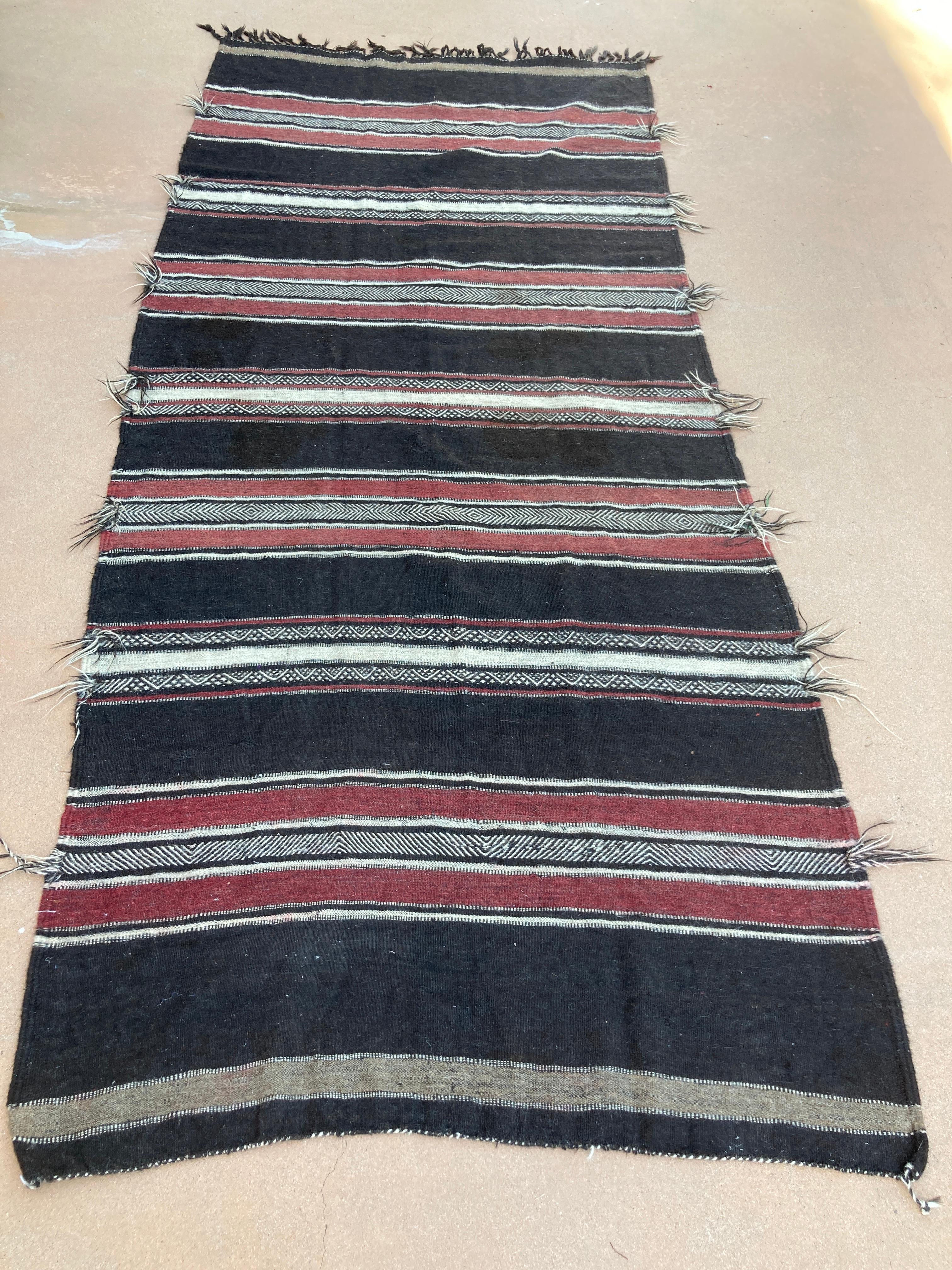Vintage Moroccan flat-weave black camel hair Tribal rug.
Large size vintage Moroccan black camel hair ethnic nomadic rug, handwoven by Berber women in south Morocco for their own use.
This rug was made using flat-weave technique with linear pattern