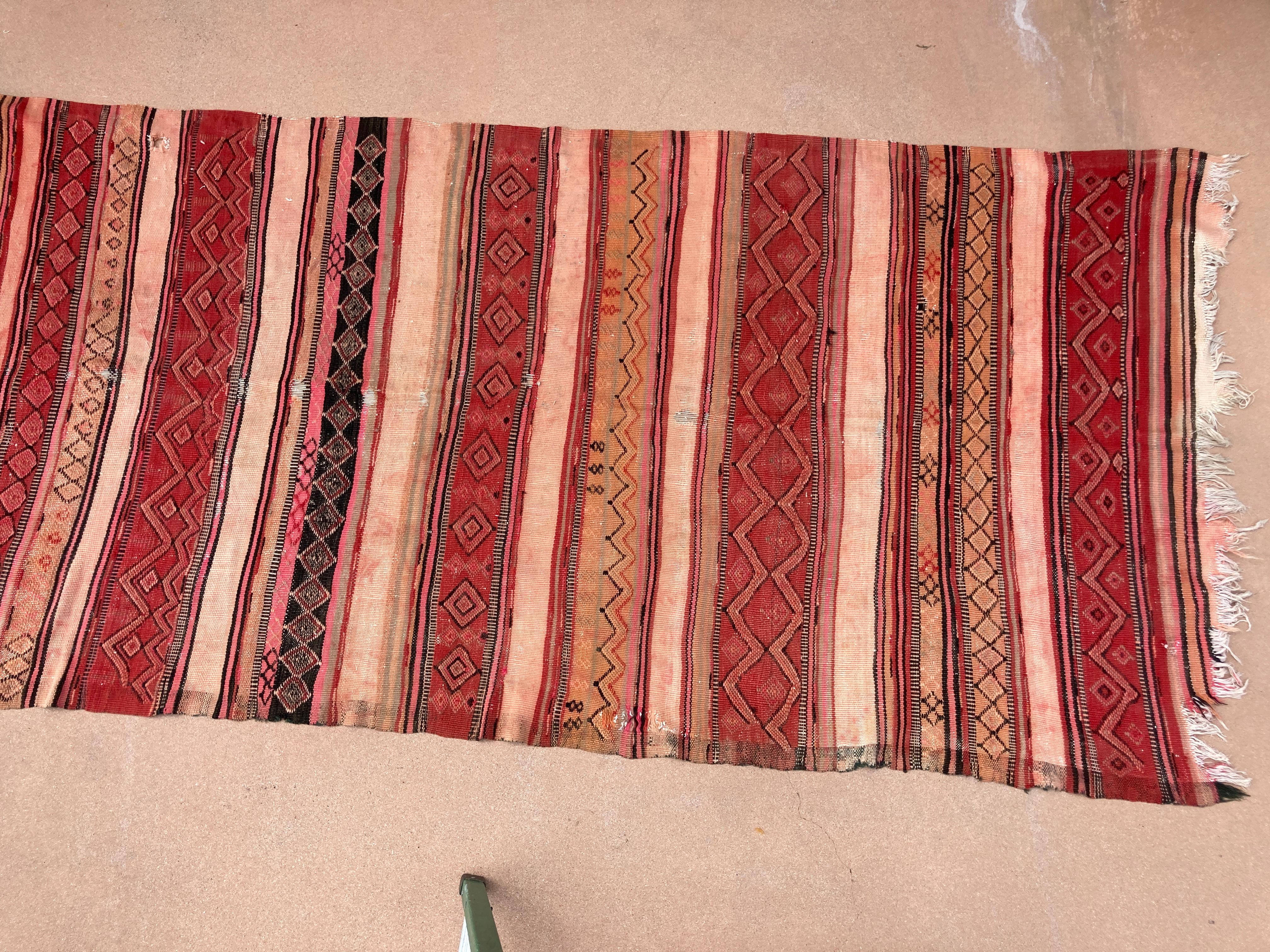 Large handwoven vintage Moroccan Berber Tribal kilim rug, nicely aged with washed out cors.Handwoven by the Berber tribes in south Morocco with traditional geometric tribal designs.South of Marrakech floor covering runner.Great Moroccan vintage