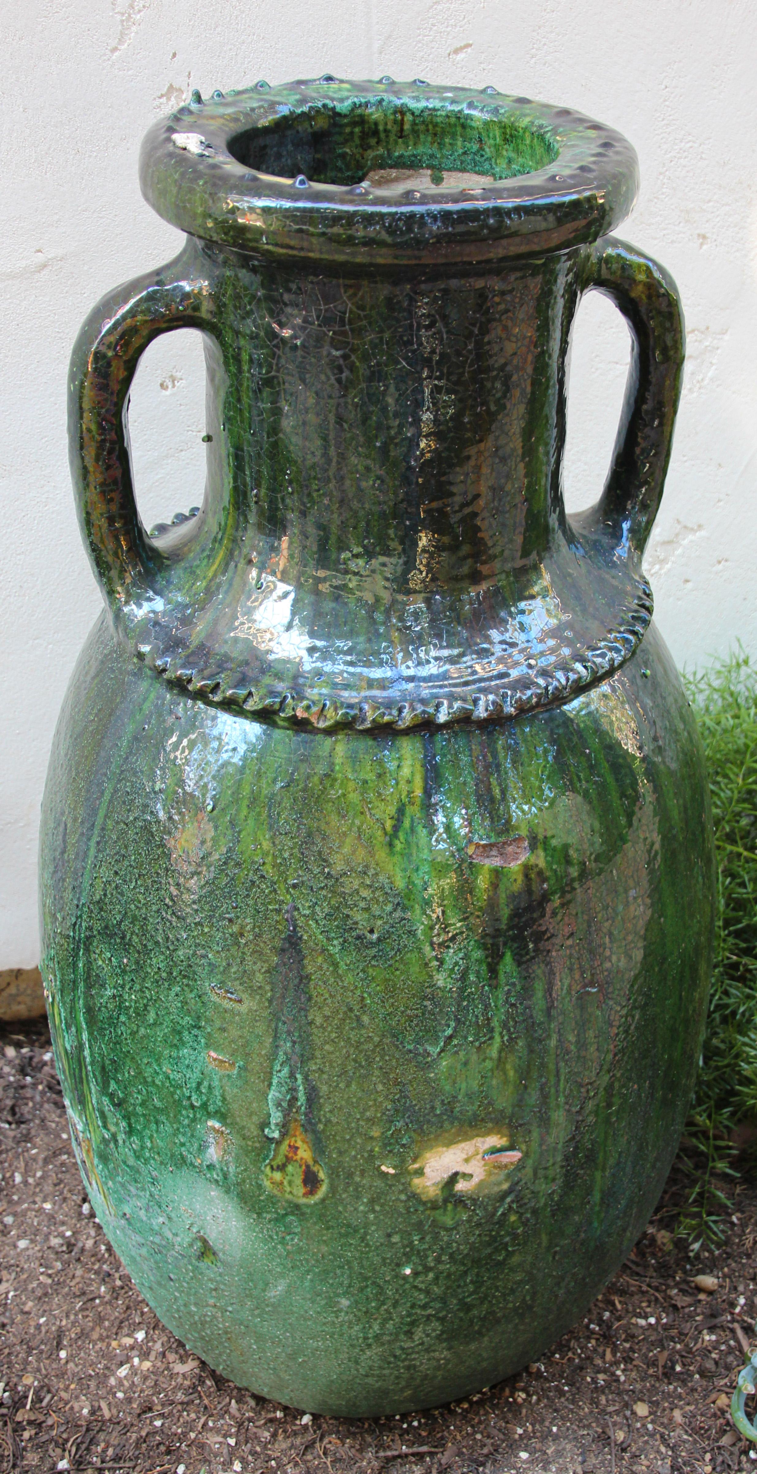 Moroccan vintage, 1960's green olive jar, or planter with handles.
 Handcrafted by the berber people in Tamgroute Morocco.
Great glazed earthenware with different hues of green and black.
A pair is available, slightly different glaze, 
Top