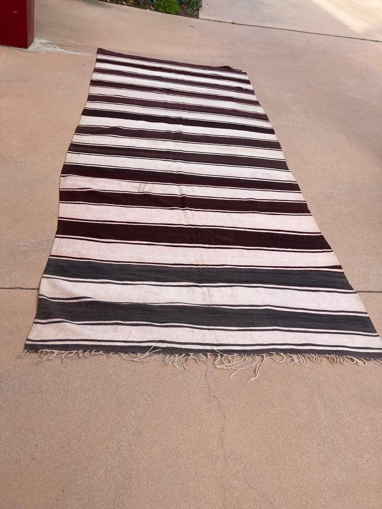 Large handwoven vintage Moroccan Berber Tribal kilim rug.
Handwoven by the Berber tribes in south Morocco with traditional stripe designs.
Midcentury organic vintage textile, circa 1960s.
Size: 5'5 x 10'.
Perfect for adding organic textile