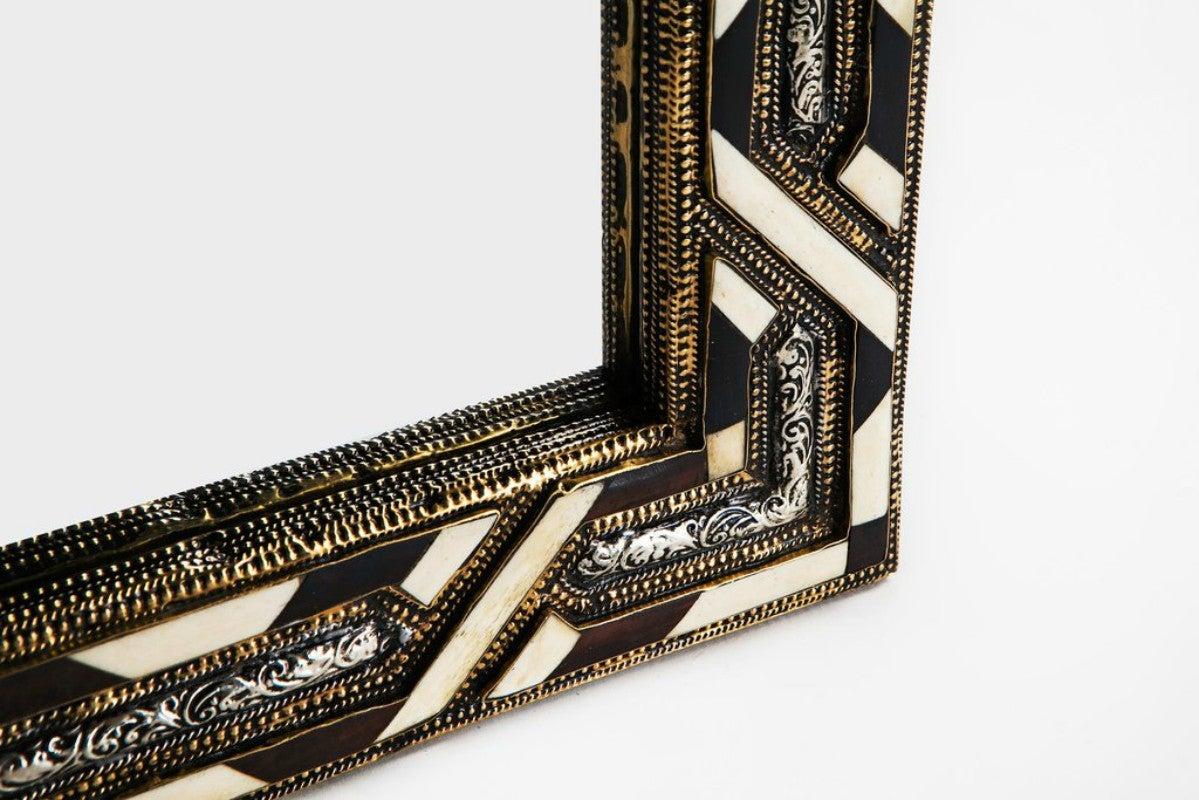 Moroccan white bone wall or console mirror in Hollywood Regency style
White a camel bones intersect with entrancing complexity in this rectangular mirror. The contrasting color scheme, the polished textures and brass frame, and the overall