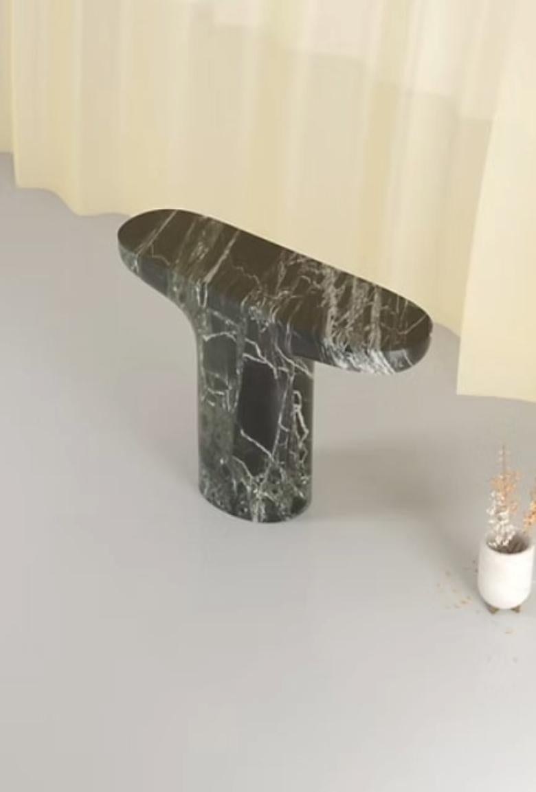 A Design That Defies Gravity. With its bold structure and material contrasts, the Morphe console plays with the perception of weight. The top surface, defined by geometric lines and sharp edges, is supported by a base sculpted with fluid forms that