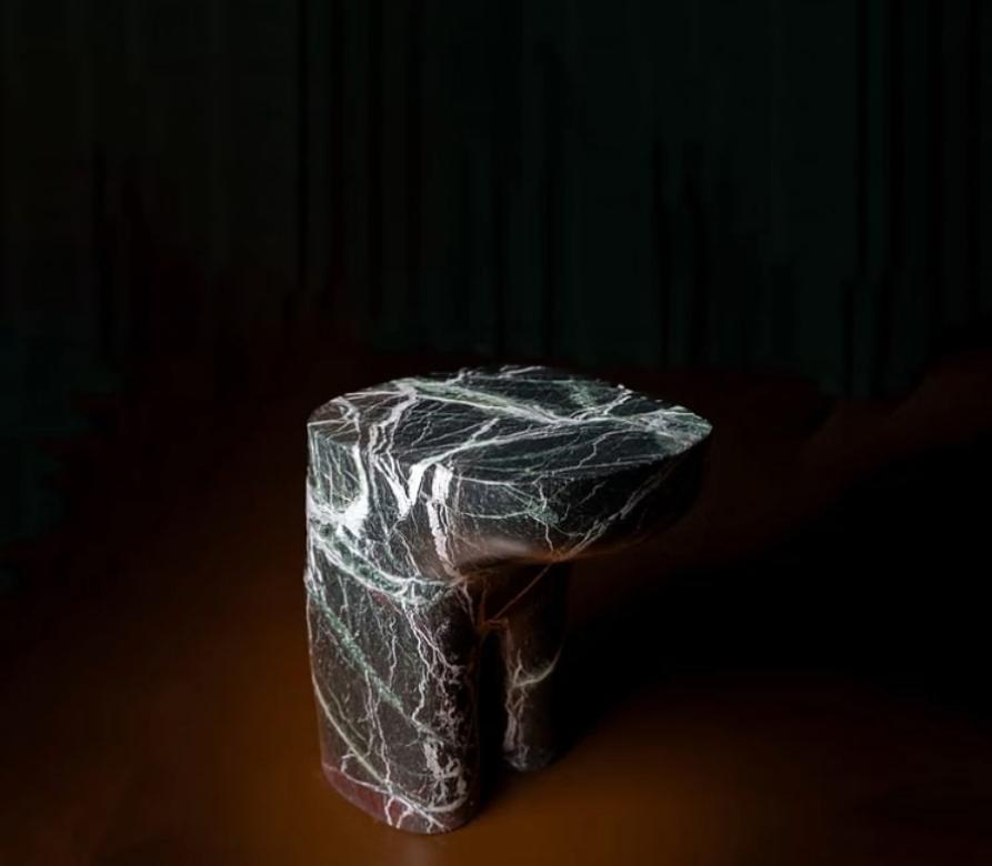 The design of the Morphe side table is based on the dialogue between rational geometry and fluid forms. The top surface, defined by clean lines and sharp angles, contrasts with a base sculpted with soft curves and slender volumes. This contrast
