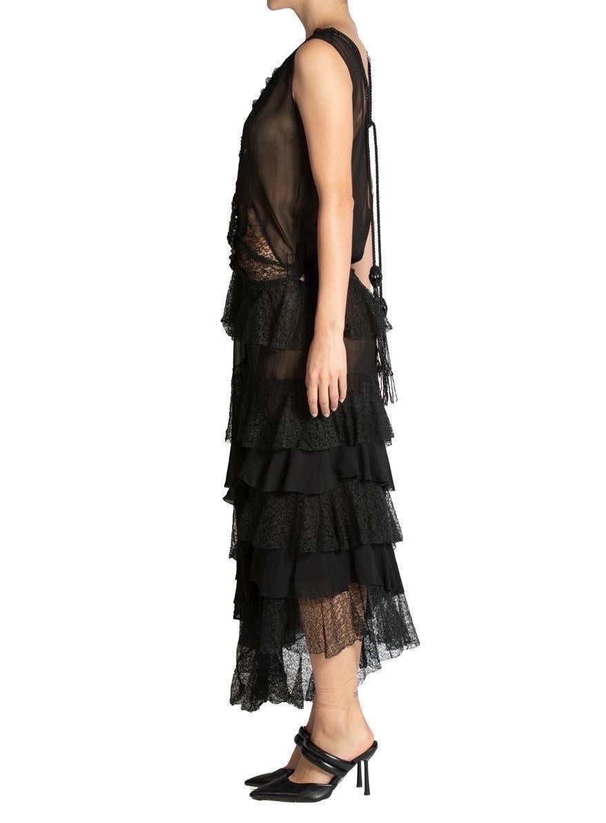 This dress is made from antique silk chiffon and lace dating from the 1920s. Low cut and detailed with Victorian lace & dramatic beaded tassels. MORPHEW ATELIER Black Low Cut Silk Chiffon & Lace Ruffled Dress With Victorian Beadwork Tassels 