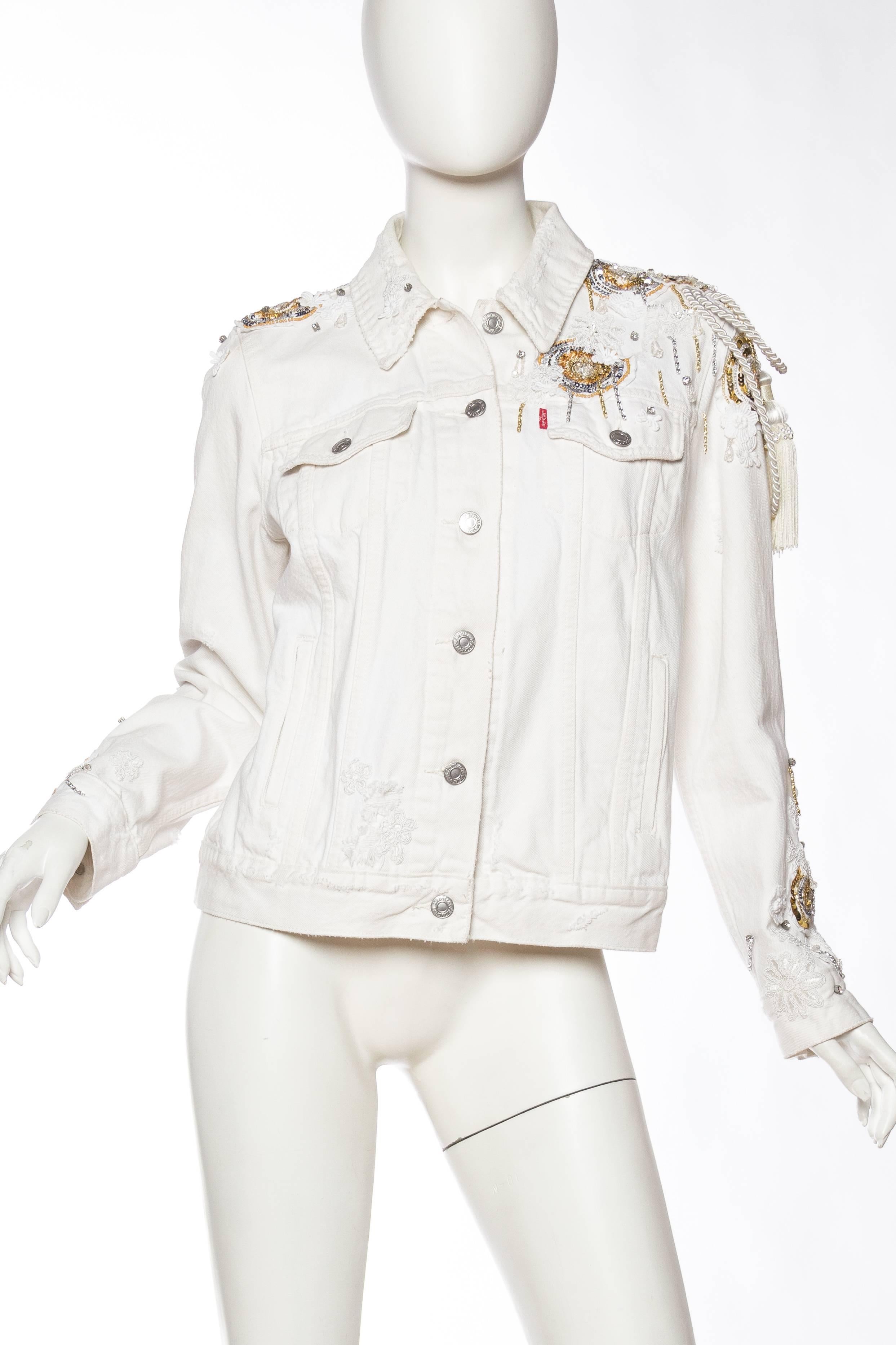 50% of this sale goes towards the Unleashed World  MORPHEW COLLECTION X UNLEASHED White Cotton Denim Gold Sequin, Lace & Crystal Embellished Jean Jacket 
MORPHEW COLLECTION is made entirely by hand in our NYC Ateliér of rare antique materials