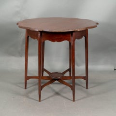 Morris & Co. Tavolino in noce con piano sagomato e grembiule ondulato.