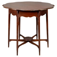 Morris & Co. Mesa auxiliar de nogal con tablero perfilado y faldón ondulado.