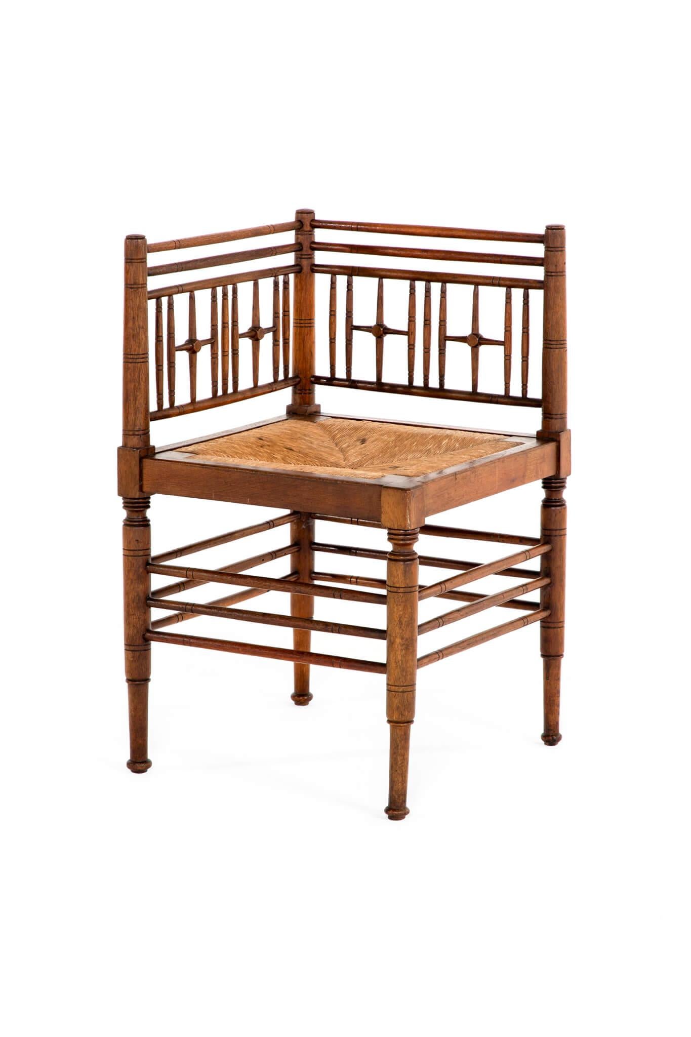 A rare Morris & Co. 19th century Sussex corner chair by Ford Maddox Brown in walnut.

The back rest is formed of three parallel stretchers and decorative turned spindles with four matching cruciform shields.

The seat has the original drop in rush