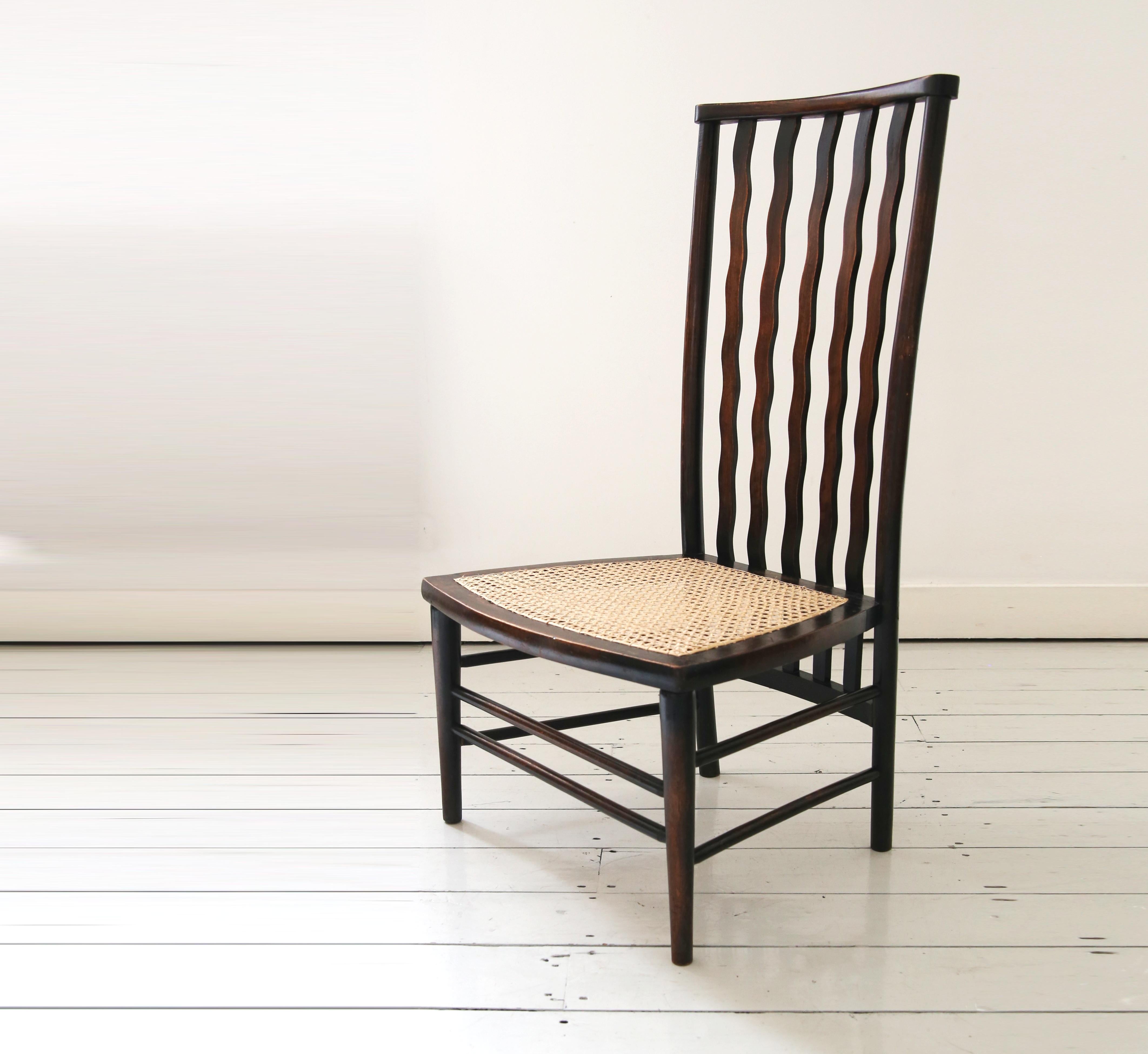 A lovely Victorian Morris & Co Arts & Crafts low chair for Liberty London, made between circa 1890 - 1920.

Featuring an elegant, elongated high back after C.R. Mackintosh's designs and fitted with a new woven cane seat, the chair's standout feature