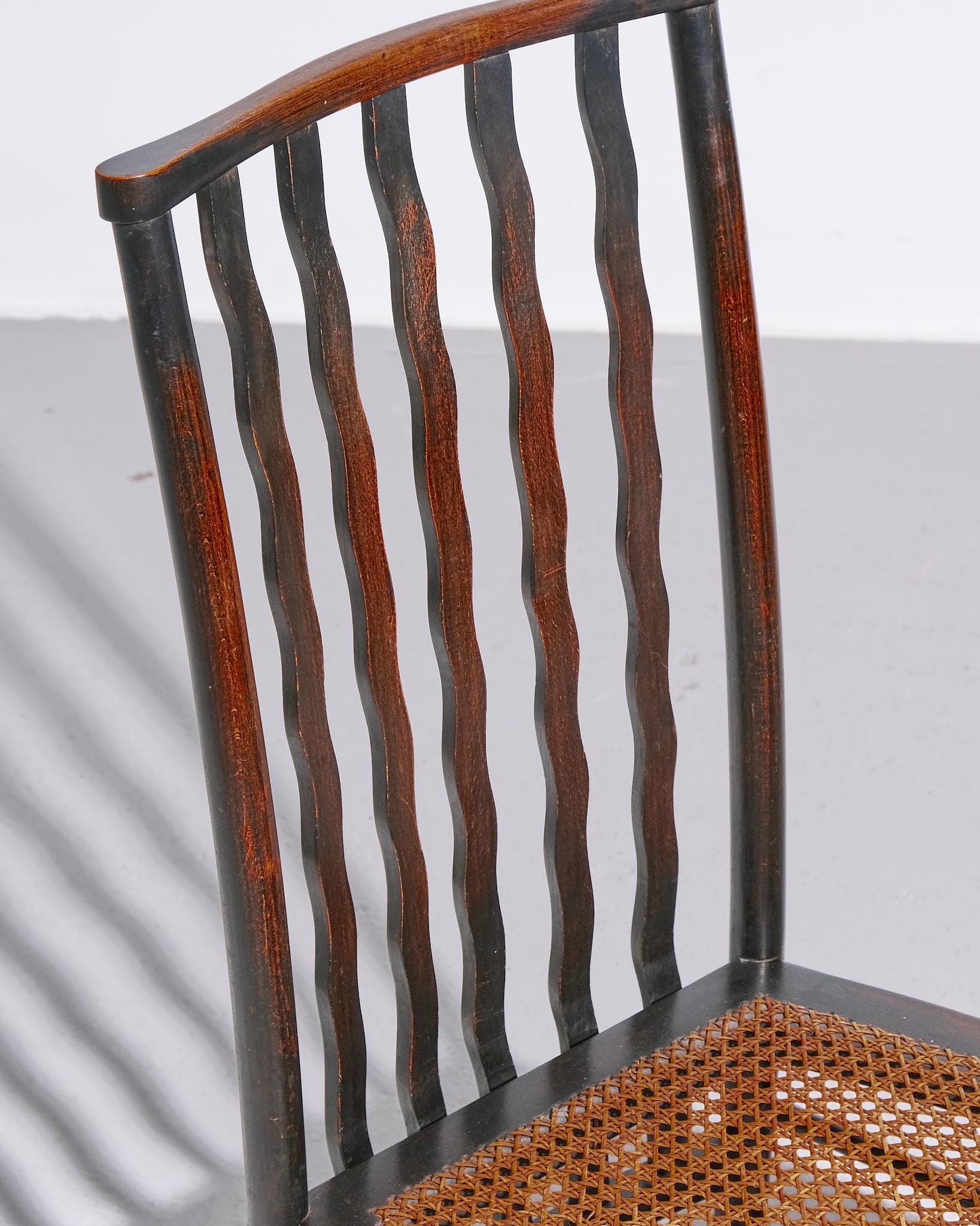 A beautifully crafted Lathback chair designed by Morris & Co. for Liberty London, dating to c.1890–1920. The chair features a wooden frame with elegant vertical slats on the backrest and a handwoven rush seat, characteristic of the Arts & Crafts