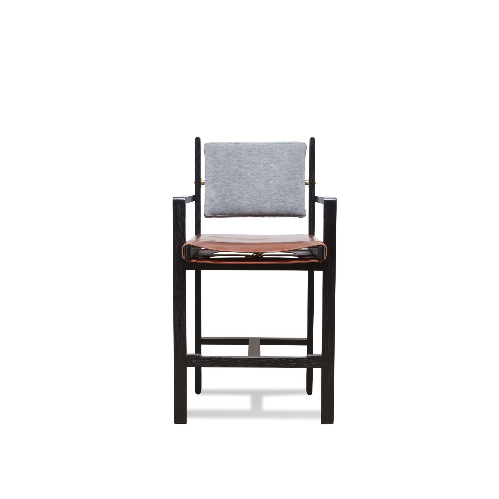 The Morro Barstool is made from a solid walnut or oak frame and features an upholstered back cushion and a leather sling seat. An optional loose seat cushion is also available. Inspired by the articulated connections of Bauhaus