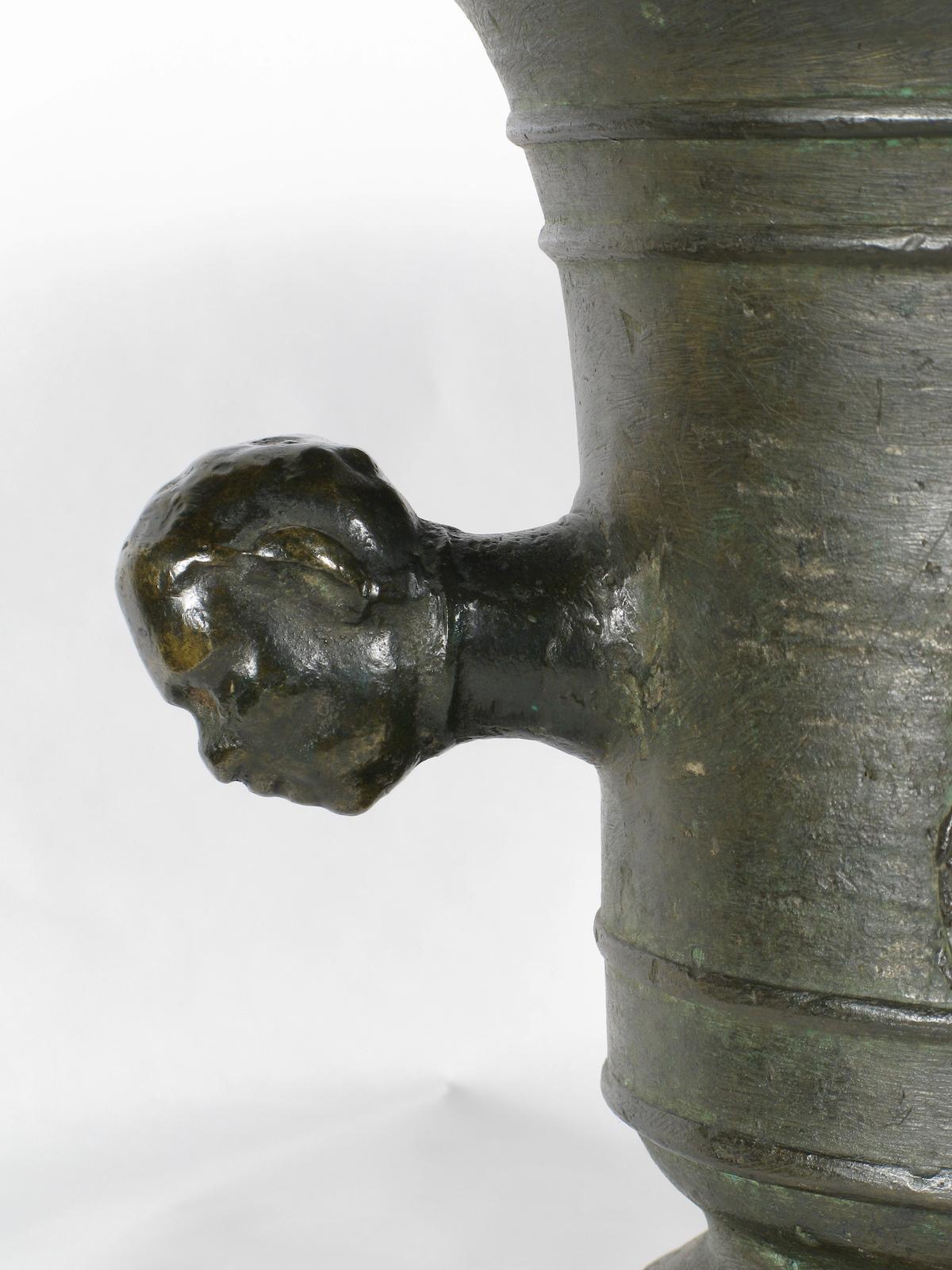 Bronze mortar, Veneto, 16th century


Lost-wax cast bronze mortar with body outlined by parallel and succeeding frames delineating its circumference.
On the two faces, in a central position, garland of flowers and fruits surmounted by the classic
