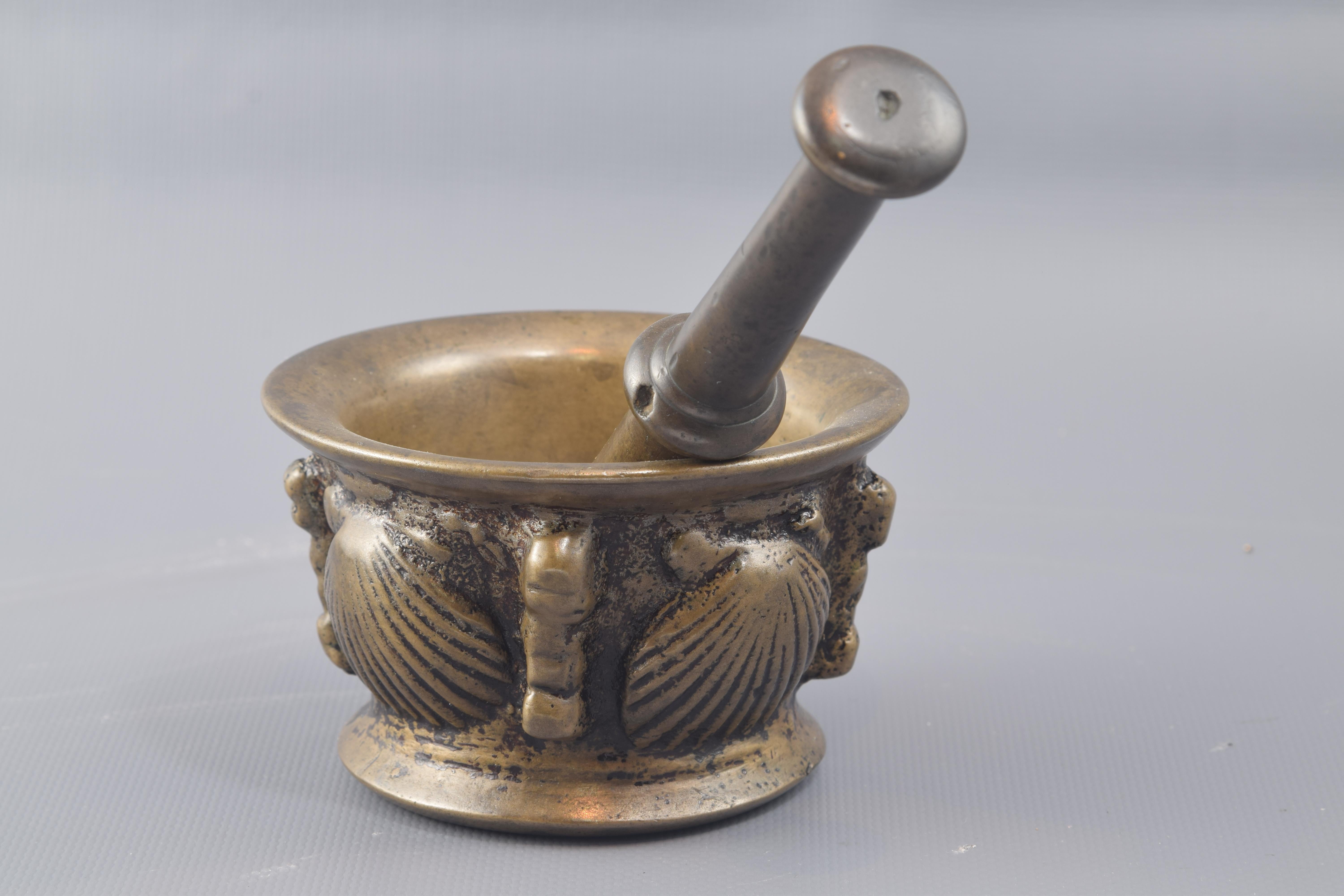 Mortar with mace. Bronze. XVII century.
 Bronze mortar with cylindrical body and edge and base exvasadas outwards decorated with a fringe of shells of great size alternated vertical shapes balustrades (derived from the usual typology of rib