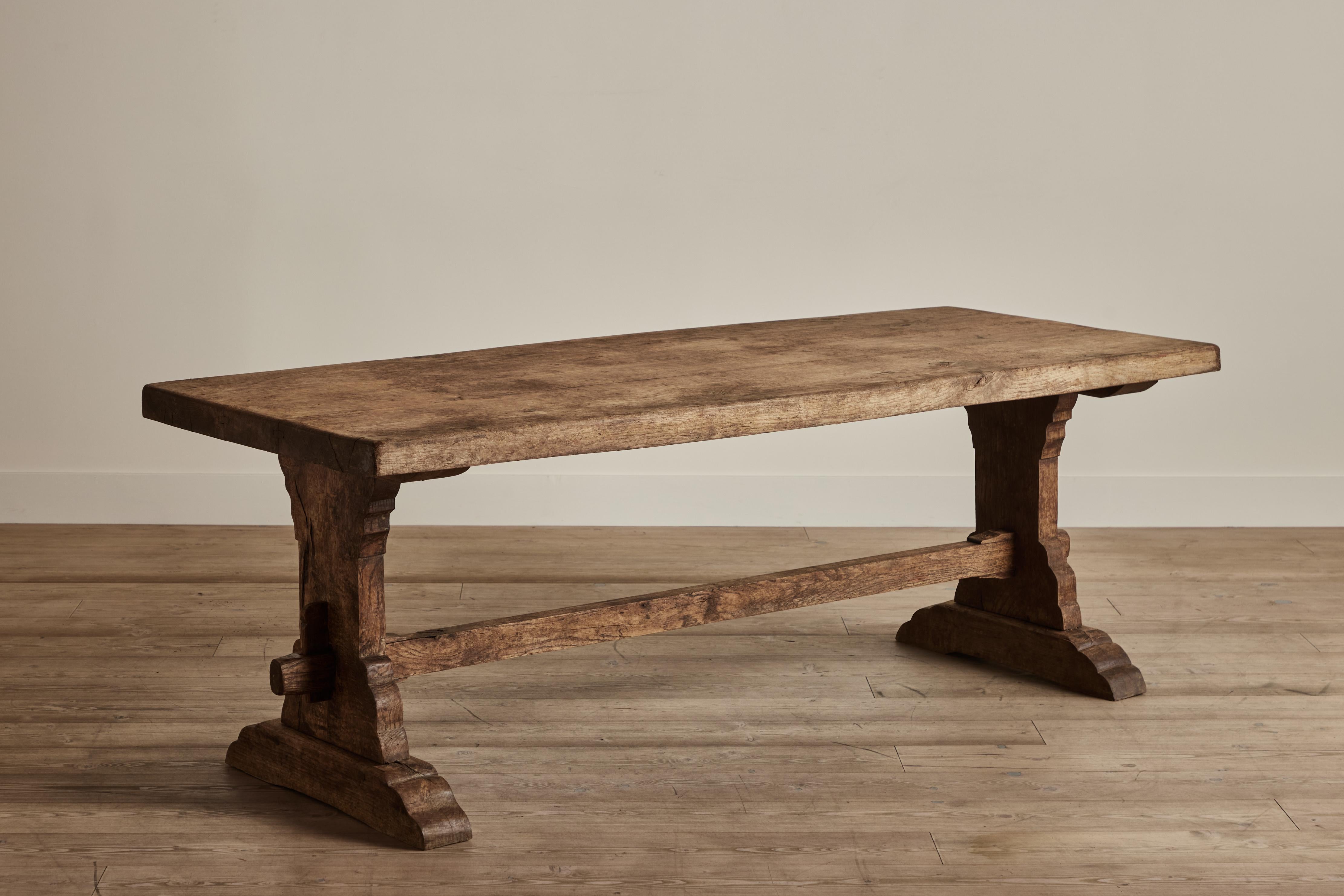 Large wood dining table from from France circa 1900 with a mortise and tenon trieste base. Visible wear on wood throughout that is consistent with age and use. 