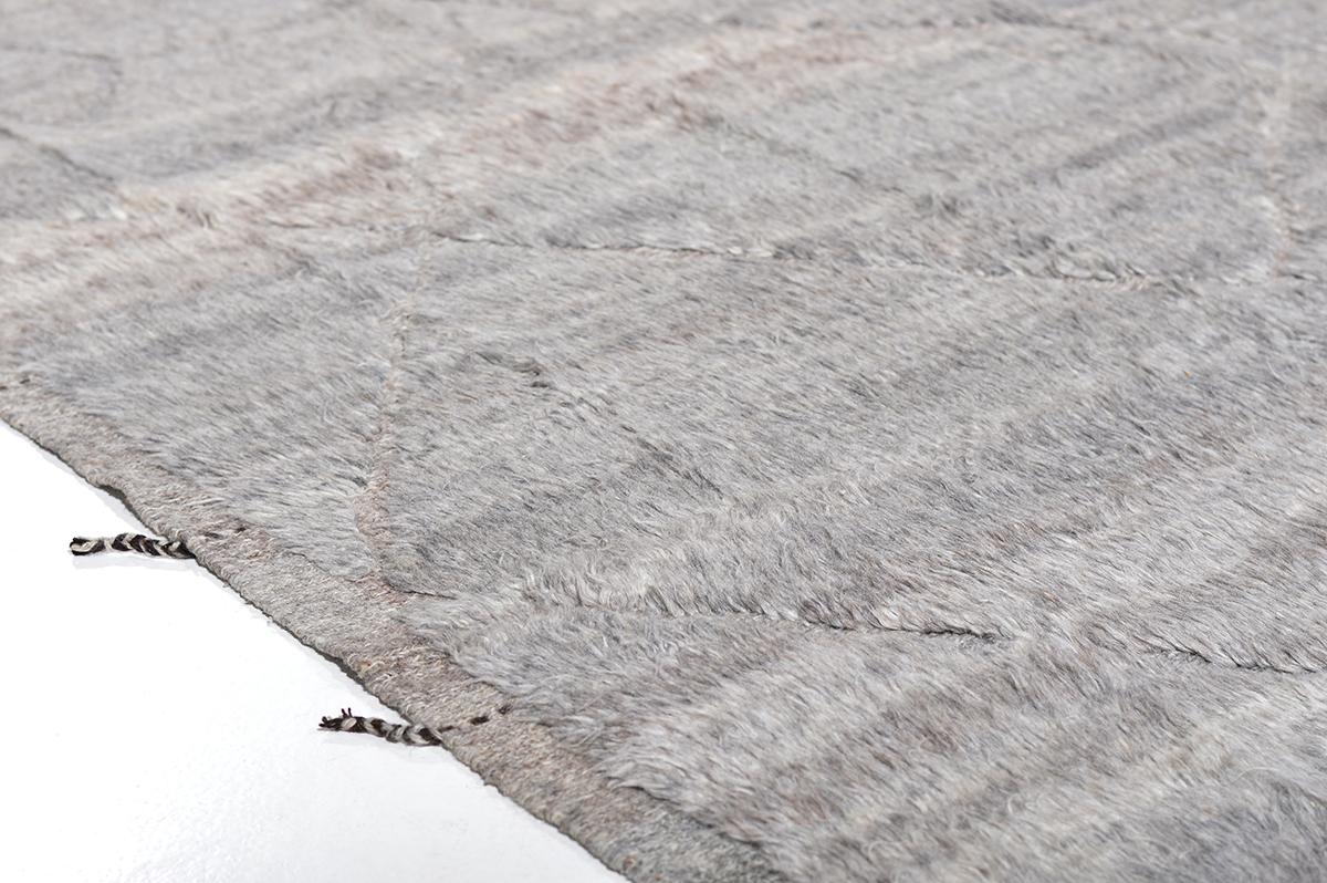 Handwoven of luxurious wool, Morus is a contemporary interpretation of a Moroccan tribal rug recreated for the modern design world. Shades of grey shag woven throughout with irregular surfaces and embossed detailing. Morus was crafted with extreme