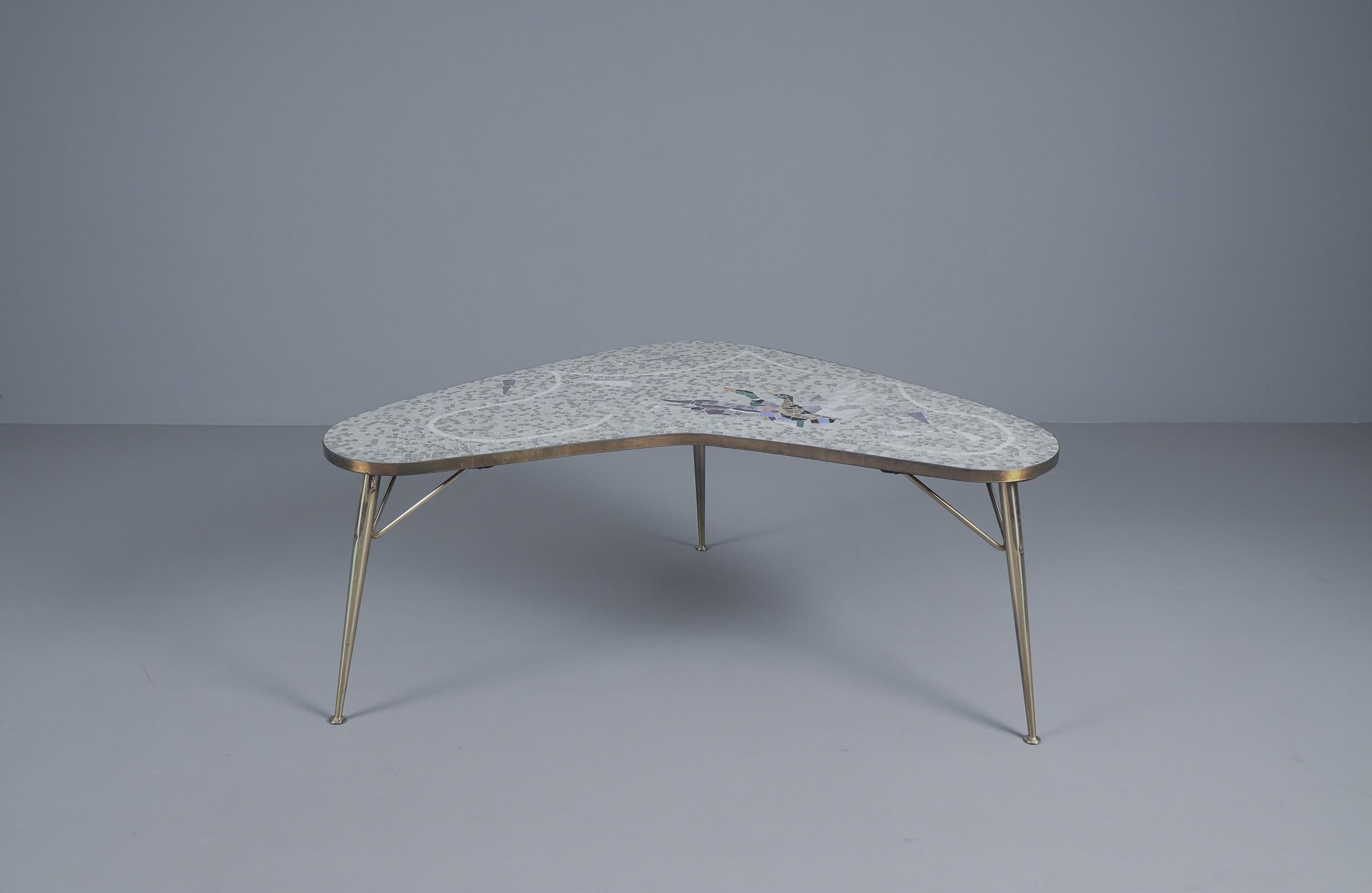 Stunning Mosaic and Brass Coffee Table by Berthold Müller-Oerlinghausen from Germany 1950s. This boomerang shaped table is in excellent condition. The mosaic pictures two ducks and has a very modern color palette. The brass is very shiny and gives