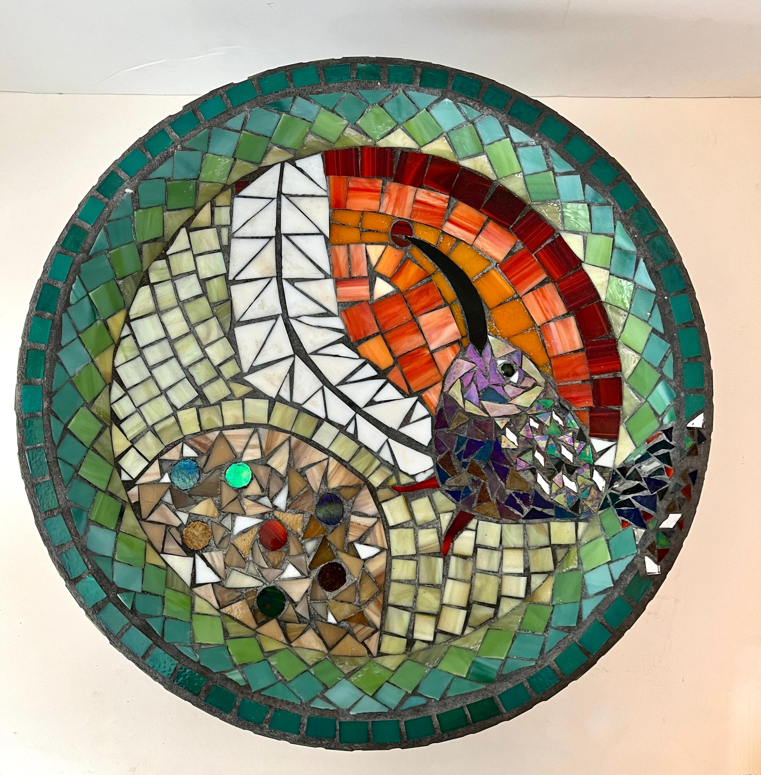 A unique mosaic tile birdbath on a base. The tiles are vibrant and cheerful - the imagery is whimsical yet sophisticated. A wonderful shallow bath for the birds, but could also be used as a place to put an equally interesting planter.

Hand made