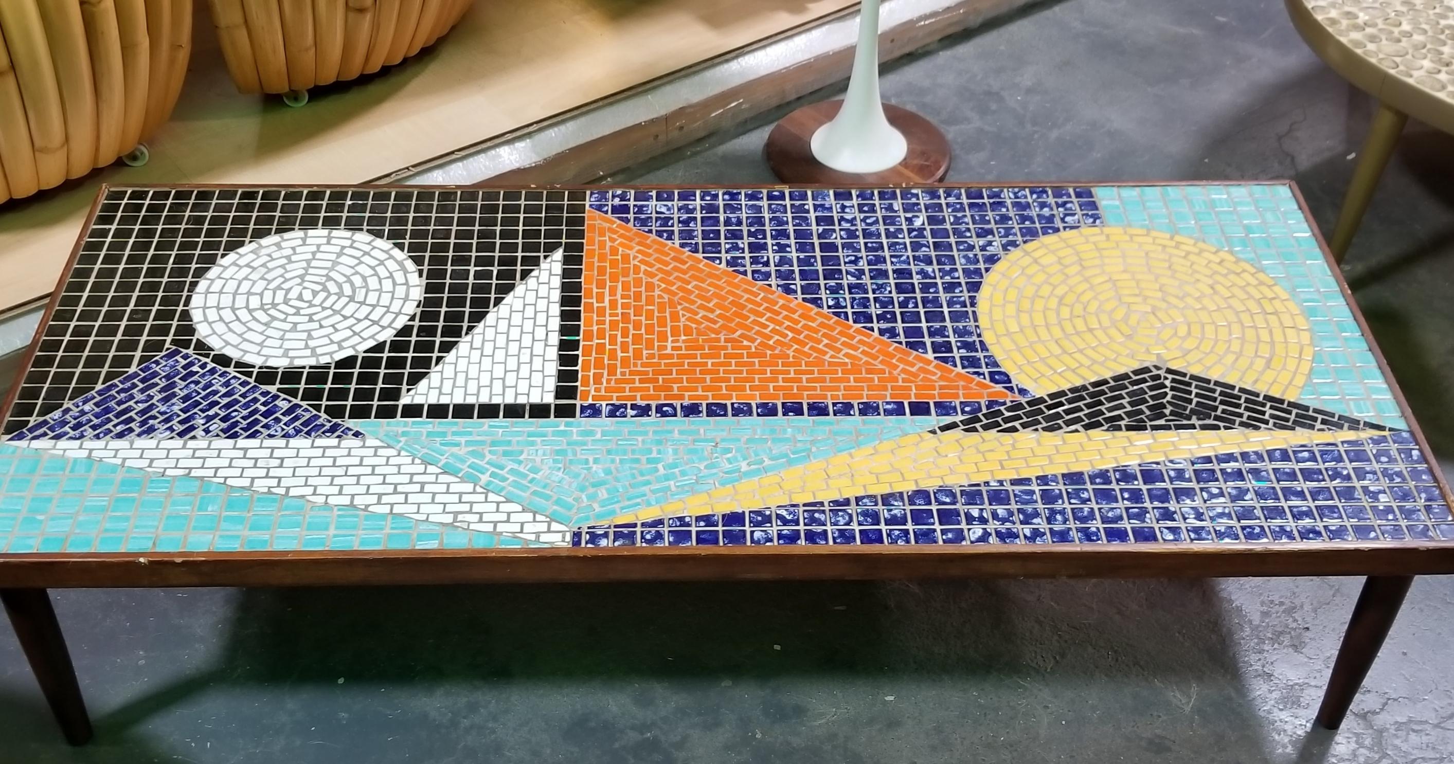 Unusual Mid-Century Modern mosaic tile coffee table with geometric multi-color tiles, circa 1960s. Vintage conical peg legs are not original to table.