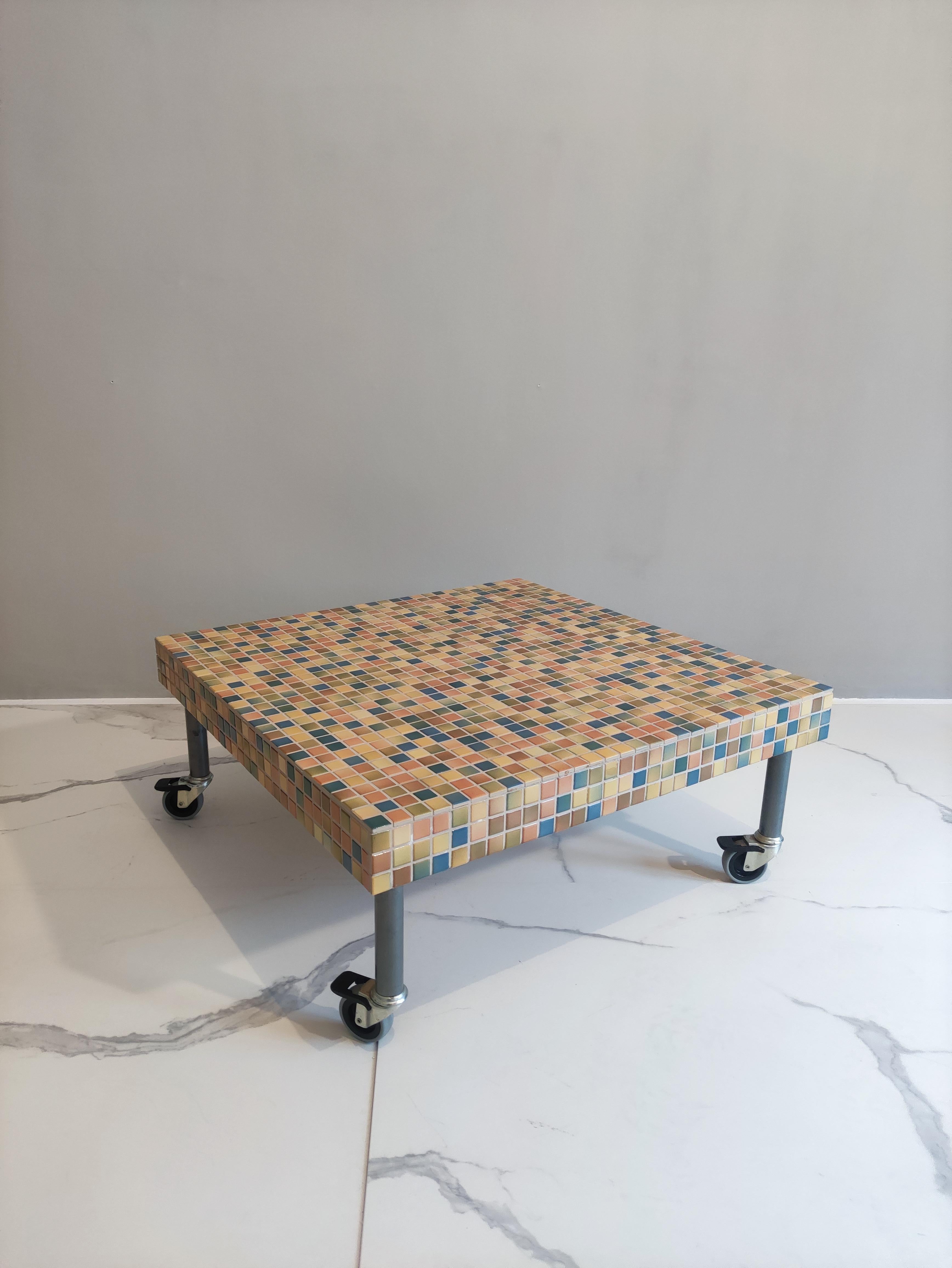 This coffee table was designed by Alessandro Mendini for Bisazza in 1995. 
The structure is made of metal and the tabletop is of wood with ceramic tiles mosaic. 
