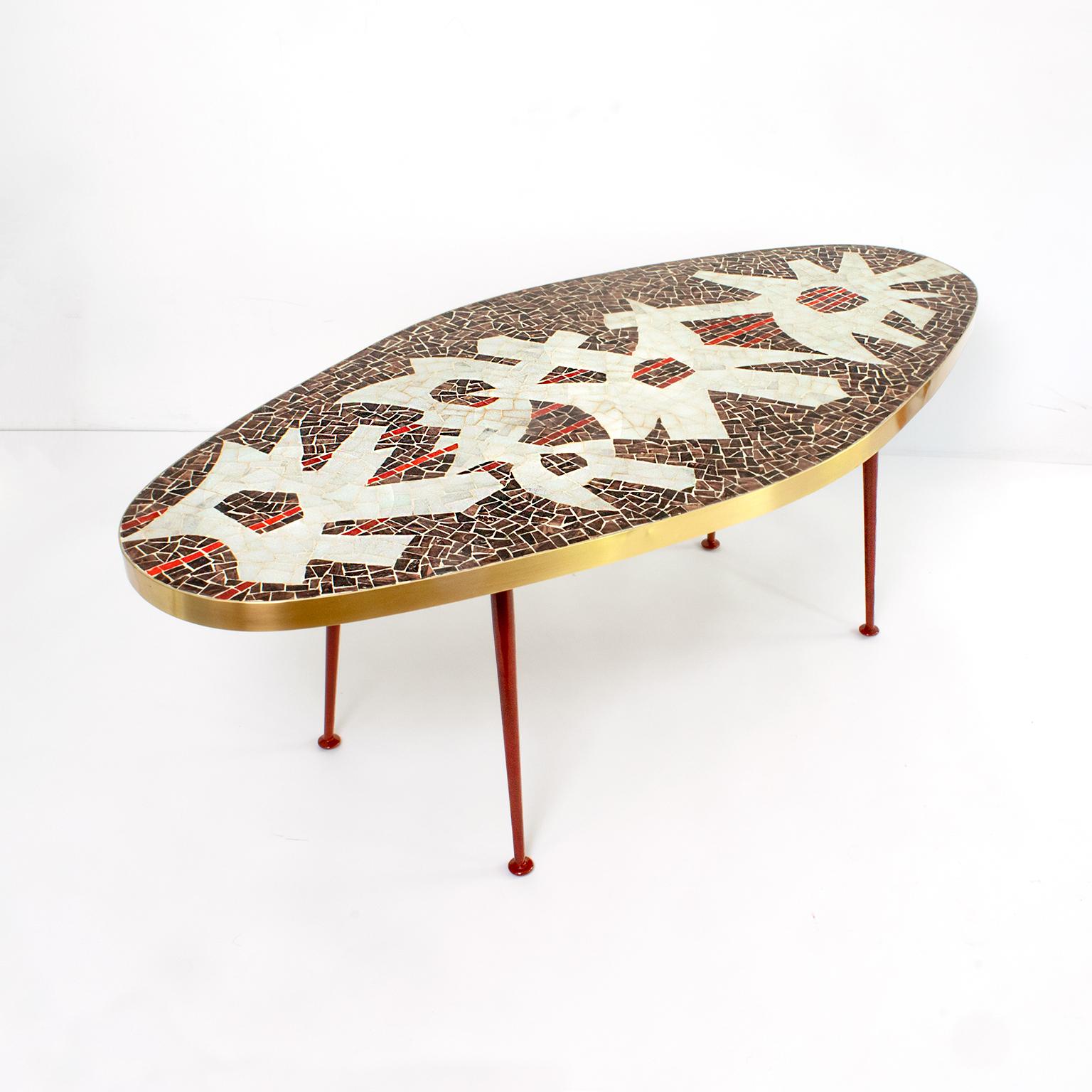 Oval shaped mosaic coffee table with abstract design and a polished brass band edge with four red lacquered legs attributed to Berthold Müller, Germany, 1960.
Newly restored.