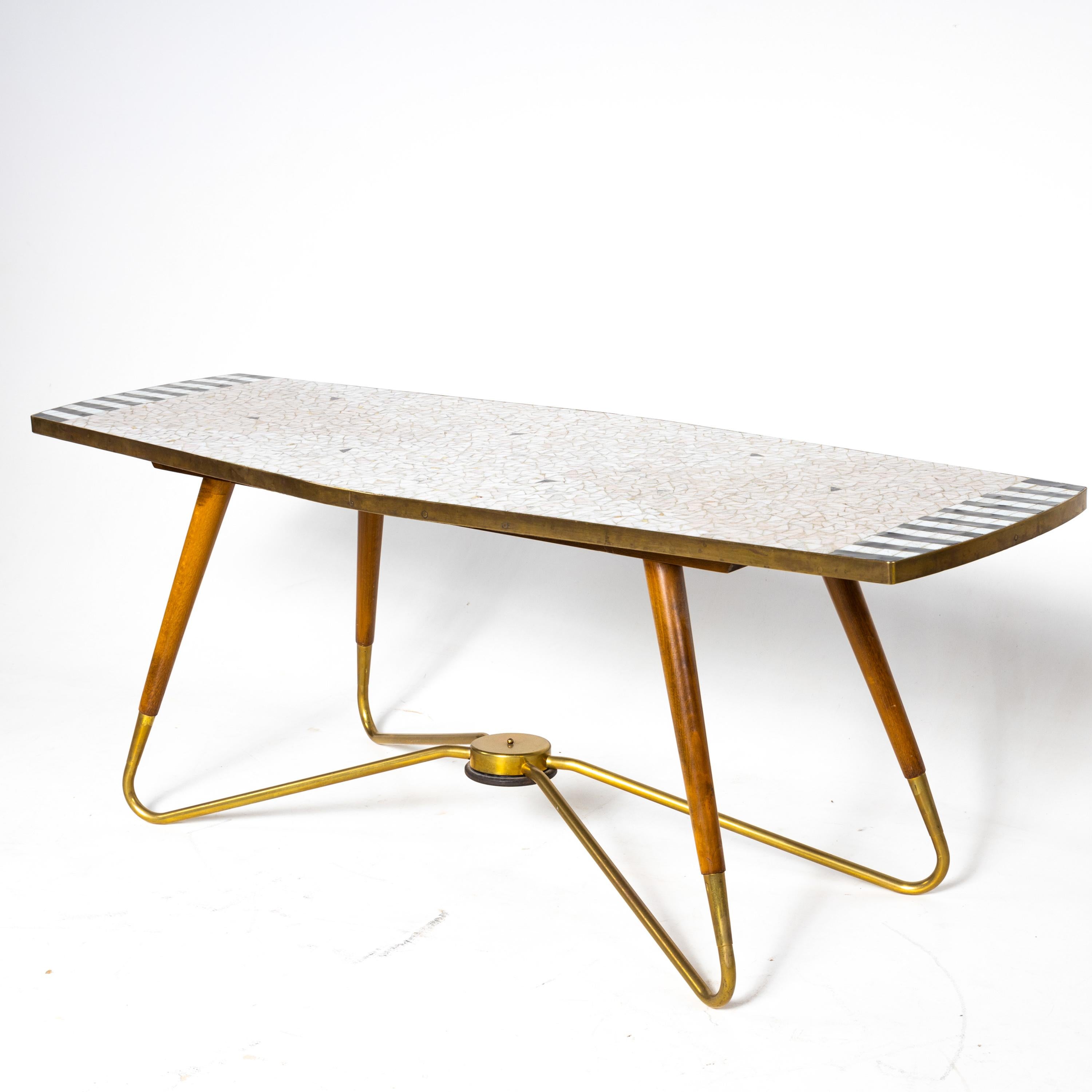 Coffee table with mosaic stone top on a curved frame of brass and wood. Stamped on the underside Ilse möbel, No. 3161.