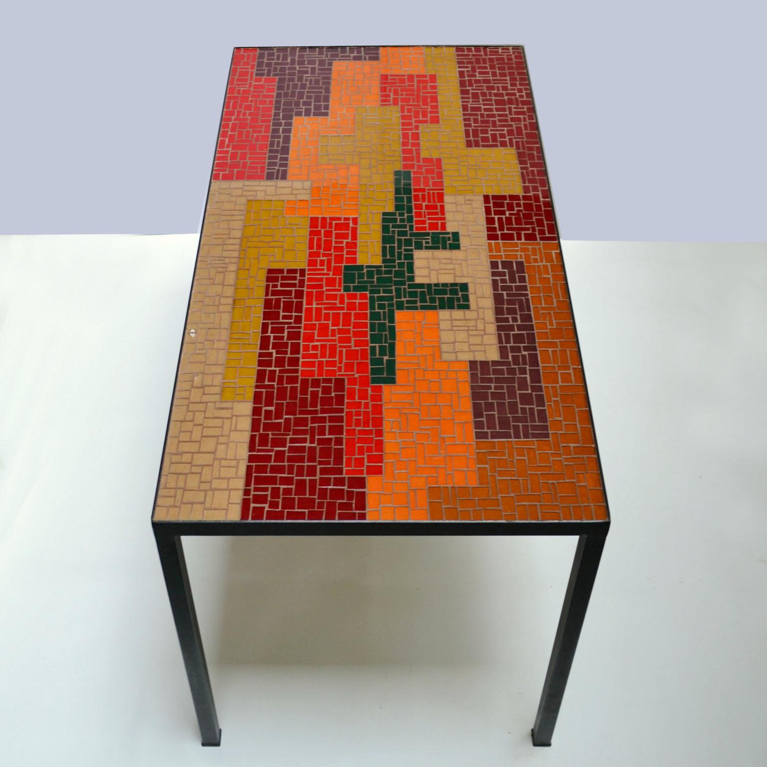 Mosaik-Couchtisch mit starkem abstraktem Design und einer ausgewogenen Farbpalette in Schwarz, Rot, Orange, Lachs und Ocker. Rechteckige und quadratische Glasstücke bilden ein auffälliges Muster in horizontaler und vertikaler Richtung. Der elegante