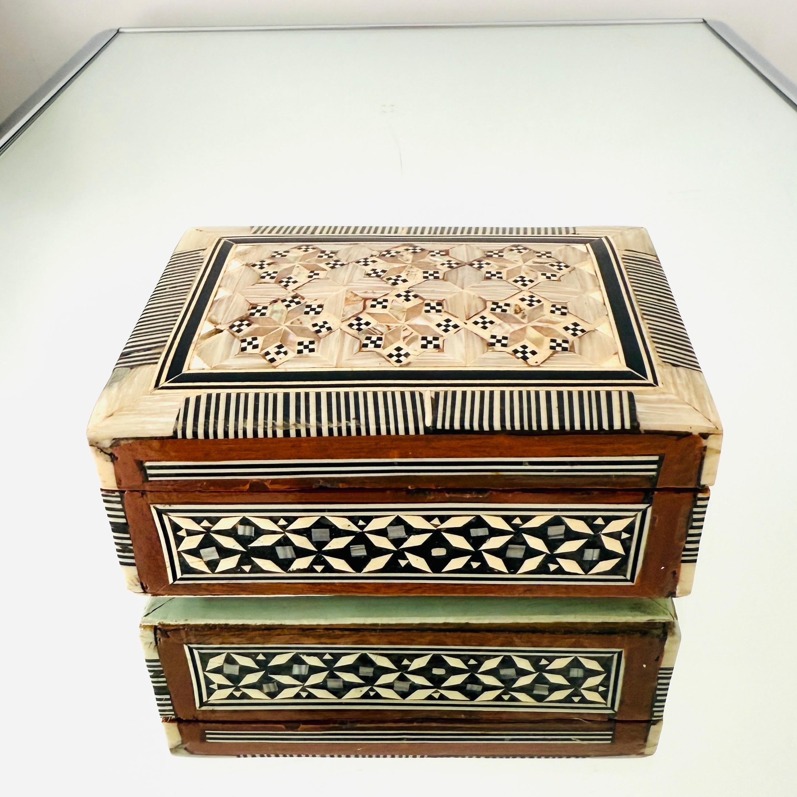 Squisita scatola in legno Khatam realizzata a mano con intarsi a micro mosaico, un'antica tecnica persiana di intarsio.  La scatola in stile moresco presenta intarsi geometrici di legno, osso e madreperla. Artigianato con coperchio a cerniera e