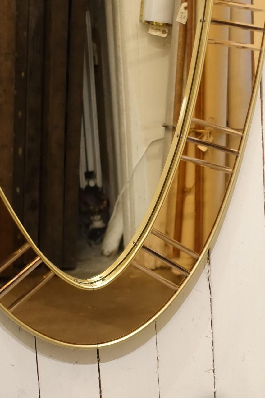 Magnificent tall vintage Italian mirror with a sophisticated oval design. Made of brass and is from the 1950s. Notice the elegant wide frame around the mirrored glass, which is made up of numerous small mirror pieces in copper coloured mirrored