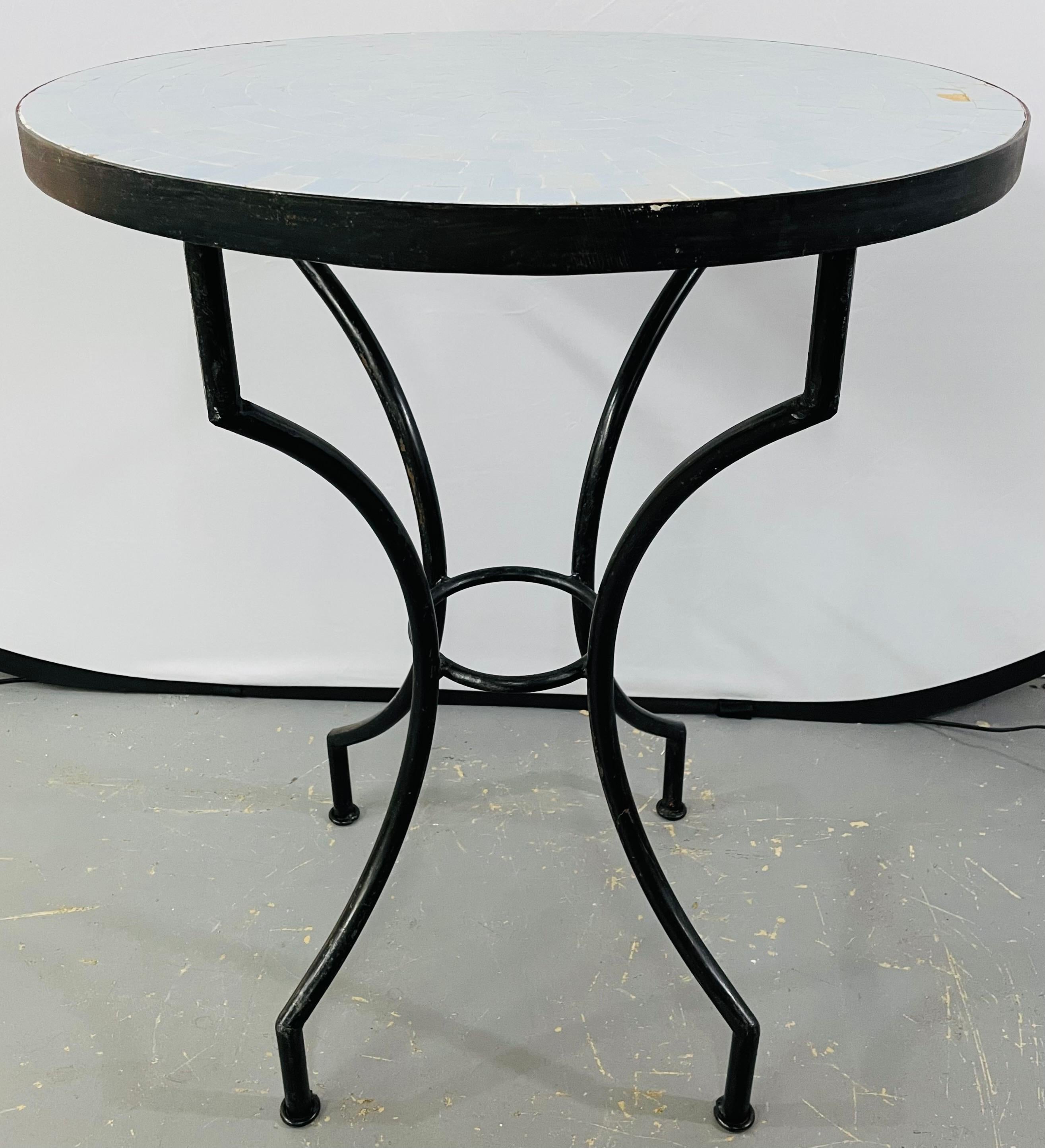A mosaic title bistro round table featuring a beautiful powder/lavender radial-style tile pattern. This lovely handcrafted garden table with wrought iron base will add style and elegance to any patio, deck, kitchen or living space. Perfect as a cafe