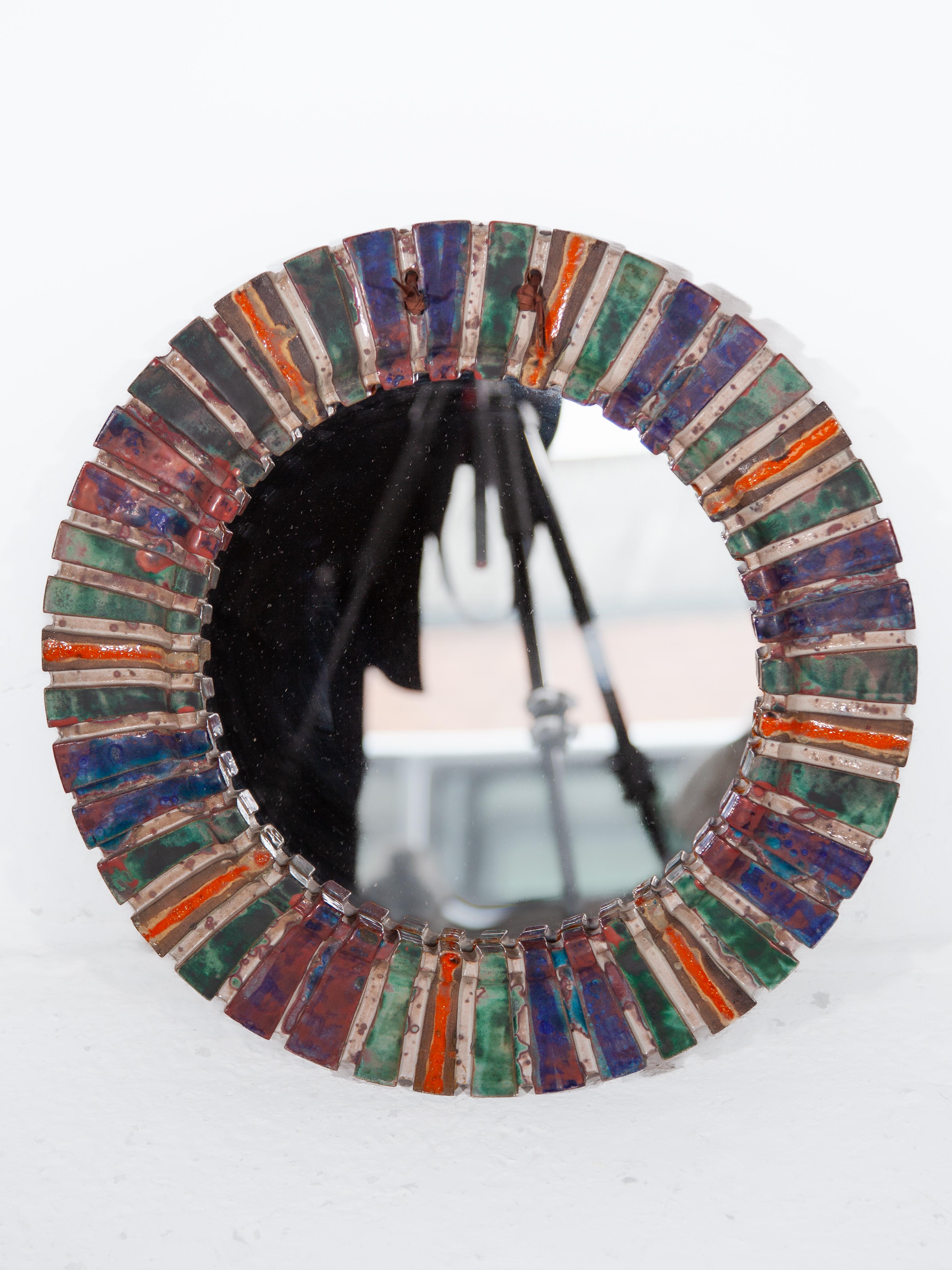 An expressive round mirror made of elongated corrugated tiles, individually glazed in the following colours: blue, orange and green. In perfect condition, designed in the sixties by Vallauris, France.