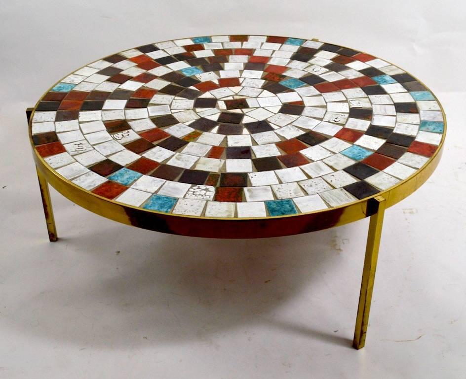 Stylish high quality mosaic top coffee table, with solid brass trim and legs.
Probably California made, midcentury period circular form coffee, cocktail table.