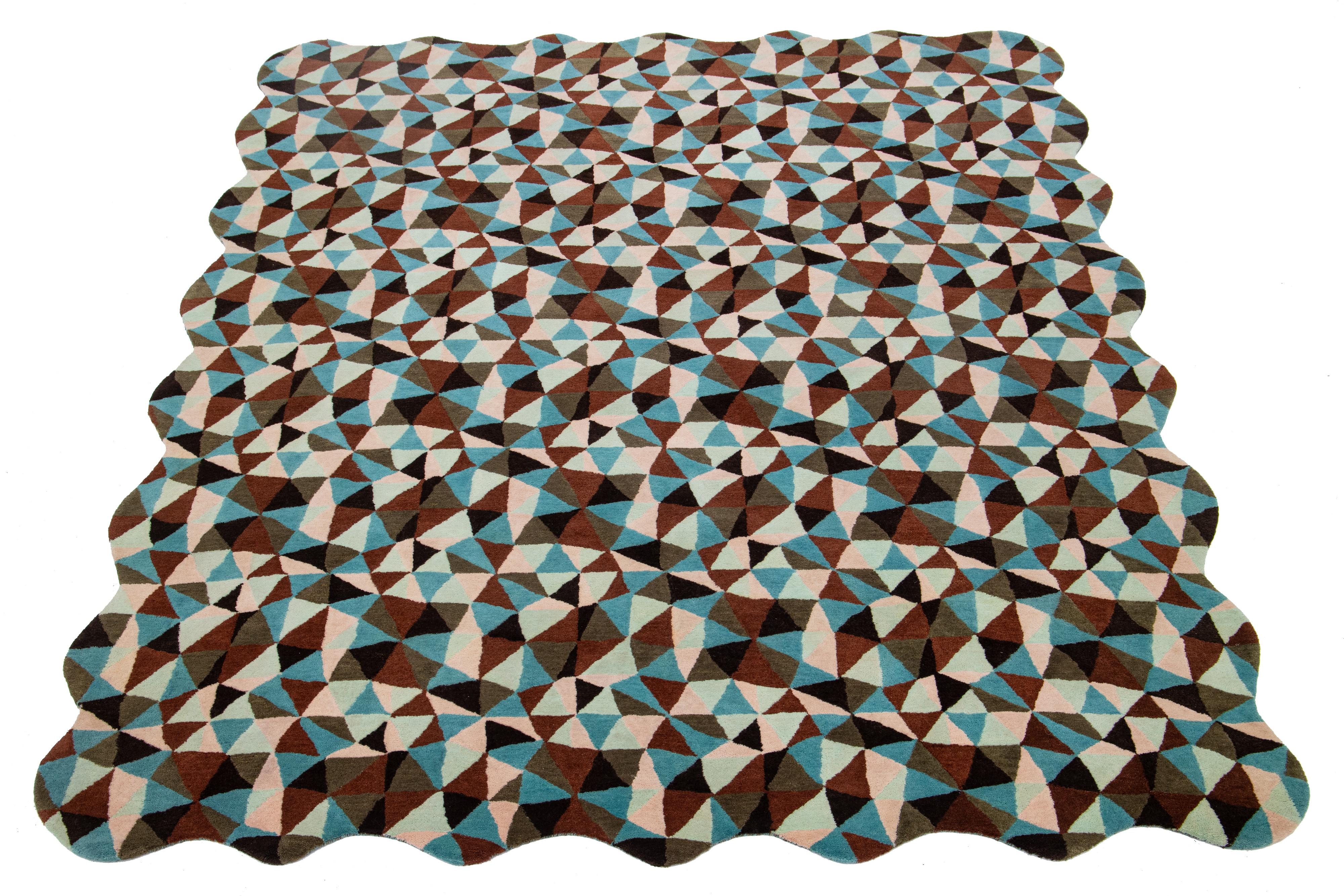 This beautiful, modern hand-tufted wool rug is part of our Laura Gottwald for Apadana Collection and features brown, blue, pink, and green fields. This Mosaico design: A kaleidoscopic repeat pattern of free-hand triangles, Mosaico is reminiscent of