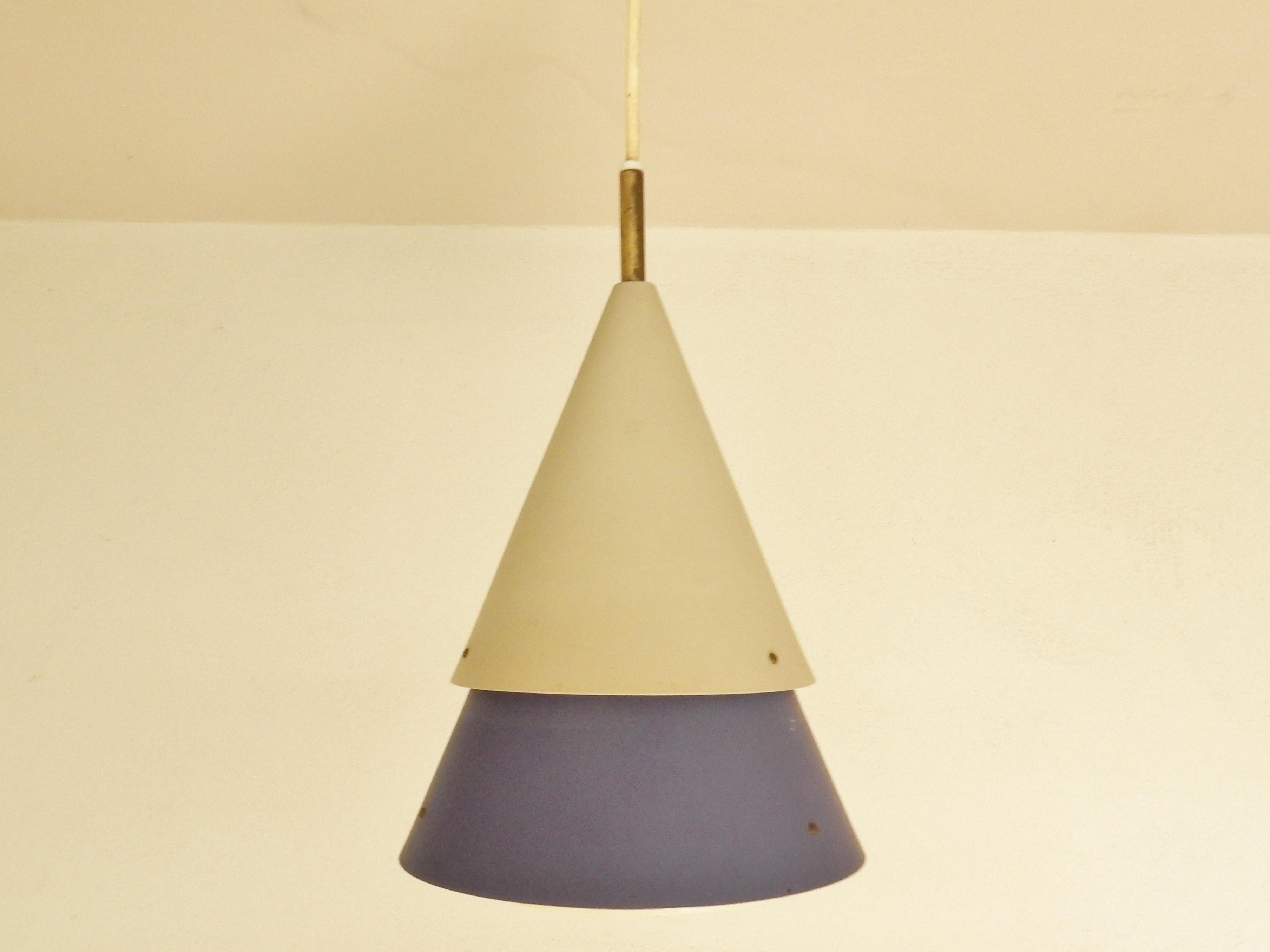 Questa rara lampada a sospensione Mosaik è un progetto degli anni '50 di Bent Karlby per Lyfa. Sono noti solo pochi modelli con questi due coni.
Di solito i coni portano separatamente un bulbo. In questo modello i due coni sono uno sopra