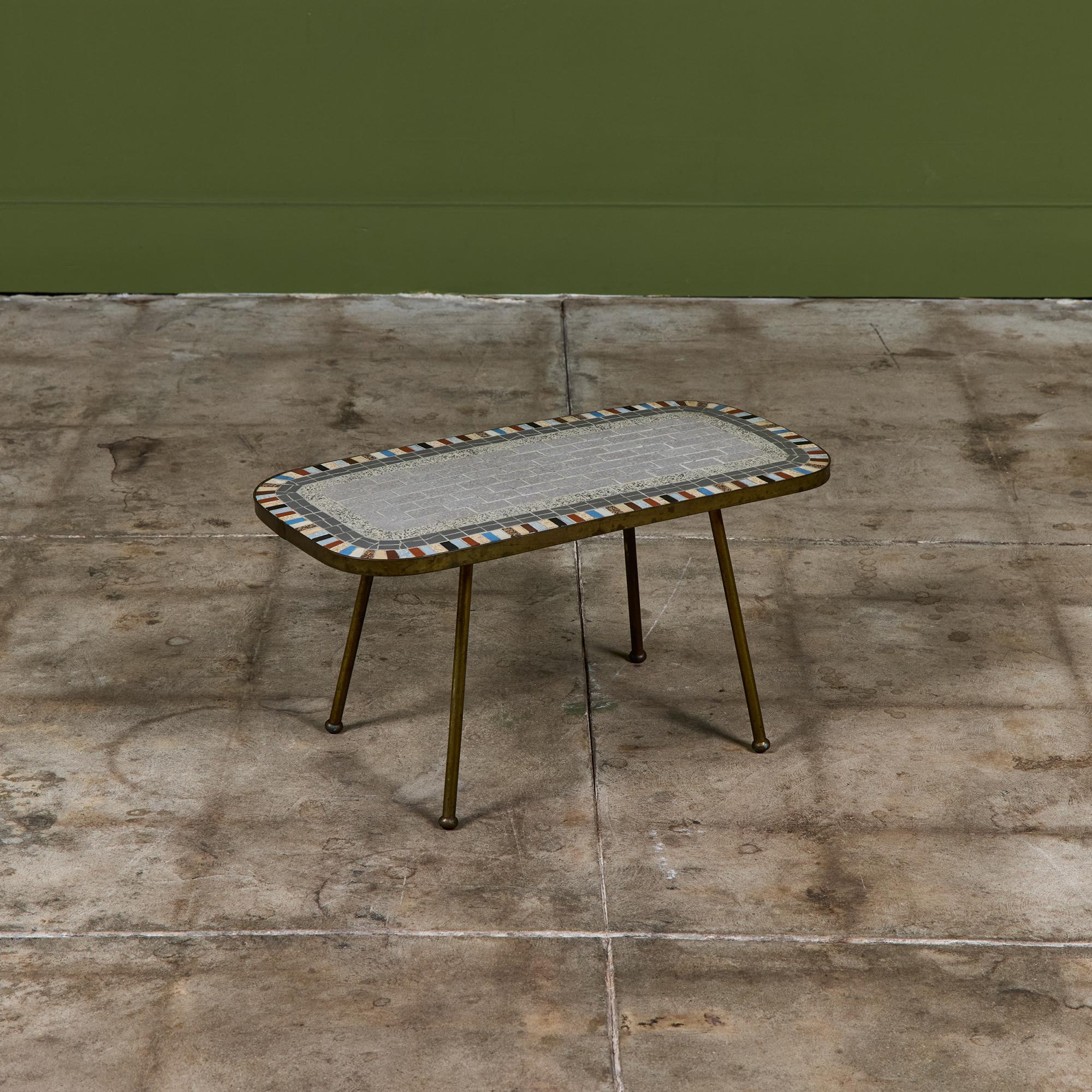 Patinated brass side table for Mosaikmöbel, c.1950s, Germany. The table features a mosaic tile table top composed of rectangular and square tiles, with a patinated brass frame and four slender legs.

Dimensions
23.5