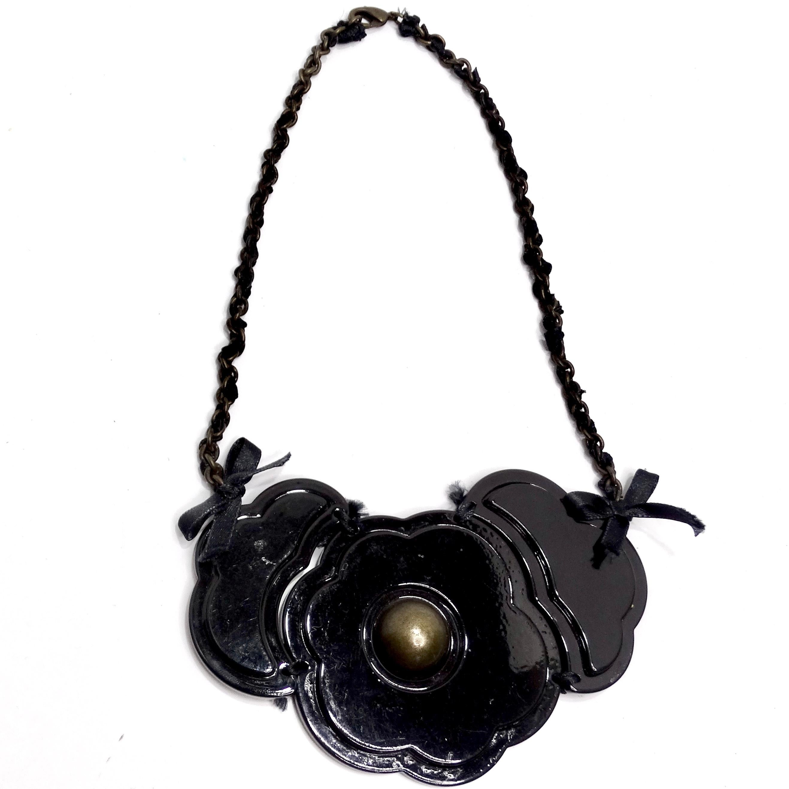 Te presentamos el Collar Flor Negra Moschino 1990: un encantador recuerdo del pasado que añade un toque de diversión y estilo a tu estilismo. Los años 90 fueron una época de moda atrevida y caprichosa, y este collar capta perfectamente ese espíritu.