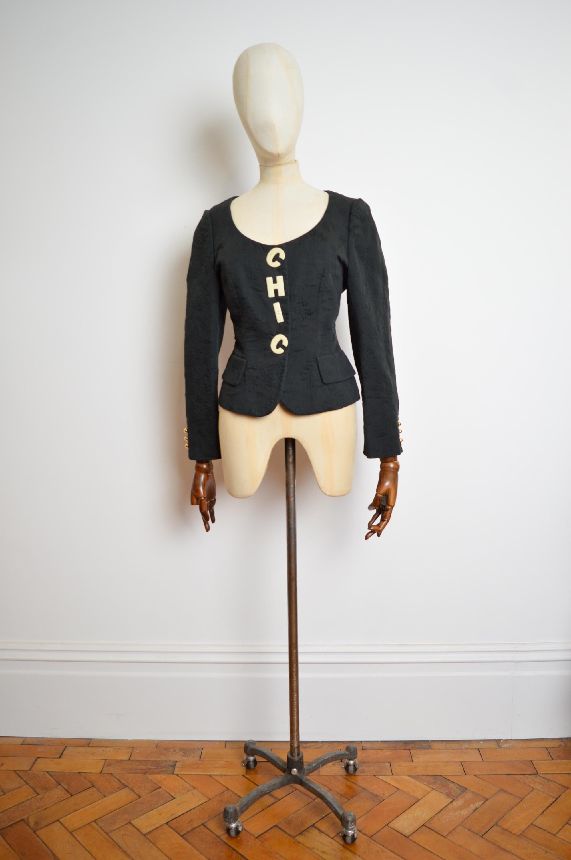 Beautiful black Jacquard Cheap & Chic jacket by Franco Moschino with Bold 'CHIC' appliqué buttons down the front. 
MADE IN ITALY 
100% Cotton
Pit to Pit; 19”
Pit to Cuff; 17”
Nape to Hem; 21”
Size; U.K. 10 (label states 12) 
Condition; 7/10 The
