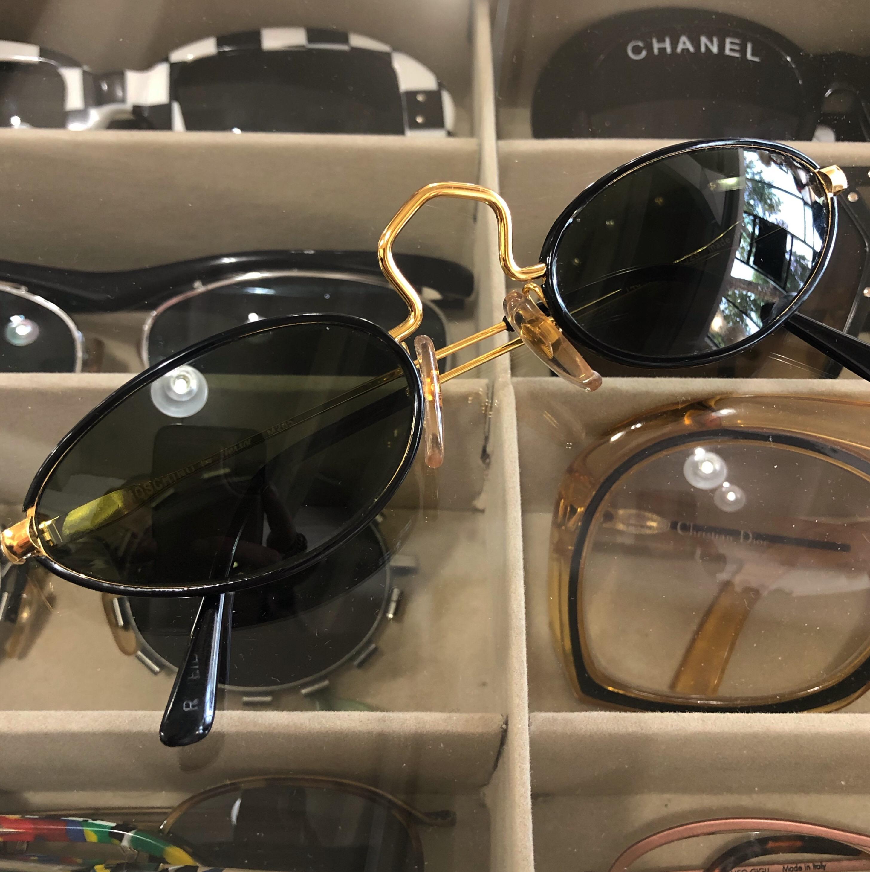 All eyes on you when you're wearing these Moschino sunnies! Circa 1990s, these Moschino for Persol sunglasses feature a black frame and gold hardware. Includes an exaggerated bridge, a Moschino stamp on the arm, and a thin oval shape. Stylish and