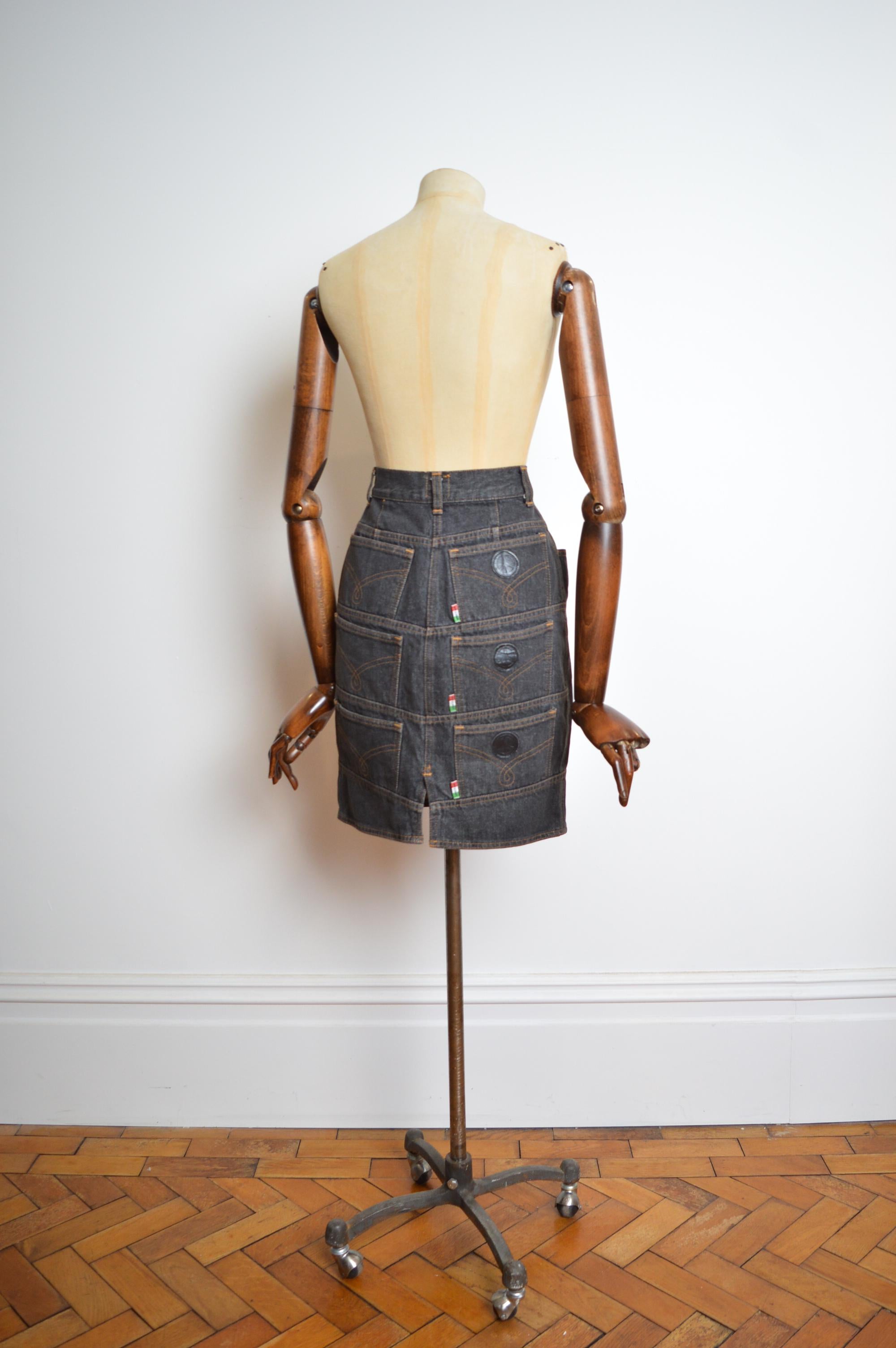 Unique and Interestingly constructed early 1990s Moschino Grey denim pencil skirt with multi pocket design reverse.
Size; 26 inch waist
Waist; 26”
Hip; 36”
Length; 20”
MADE IN ITALY. 
Condition; 8/10 Overall great condition the peace logos are ever