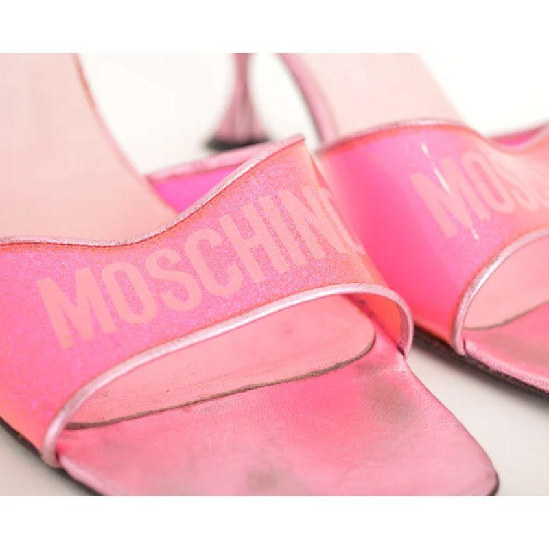 Simples et étincelants, les kitten heels roses Moschino des années 2000 sont dotés de brides en vinyle rose étincelant et du logo MOSCHINO imprimé. 

Semelles en cuir
Design/One simple
Fabriqué en Italie

Taille : 
EU 38 / UK 5
Taille du talon :